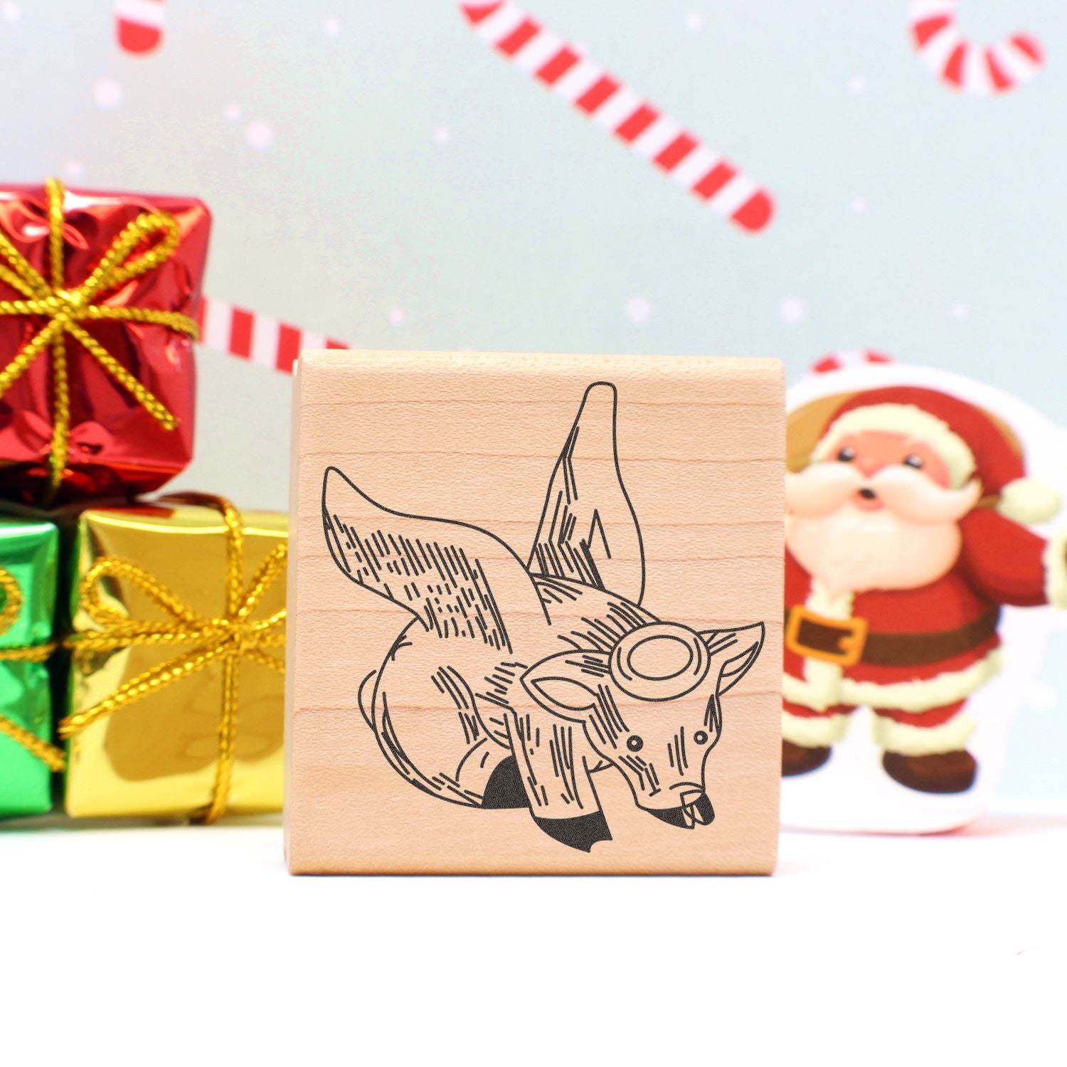Wooden fox stamp with Christmas gifts and Santa holiday decor background