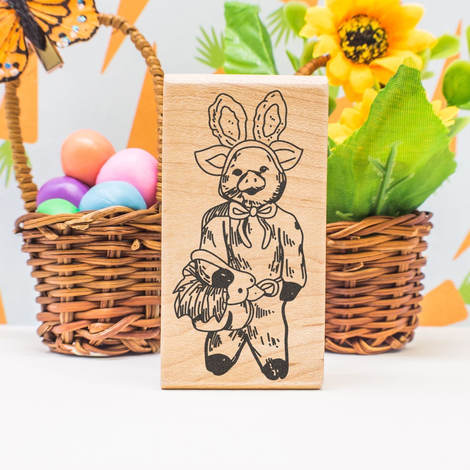 Wooden Easter stamp featuring a pig in bunny ears with colorful Easter eggs and spring flowers in woven baskets.