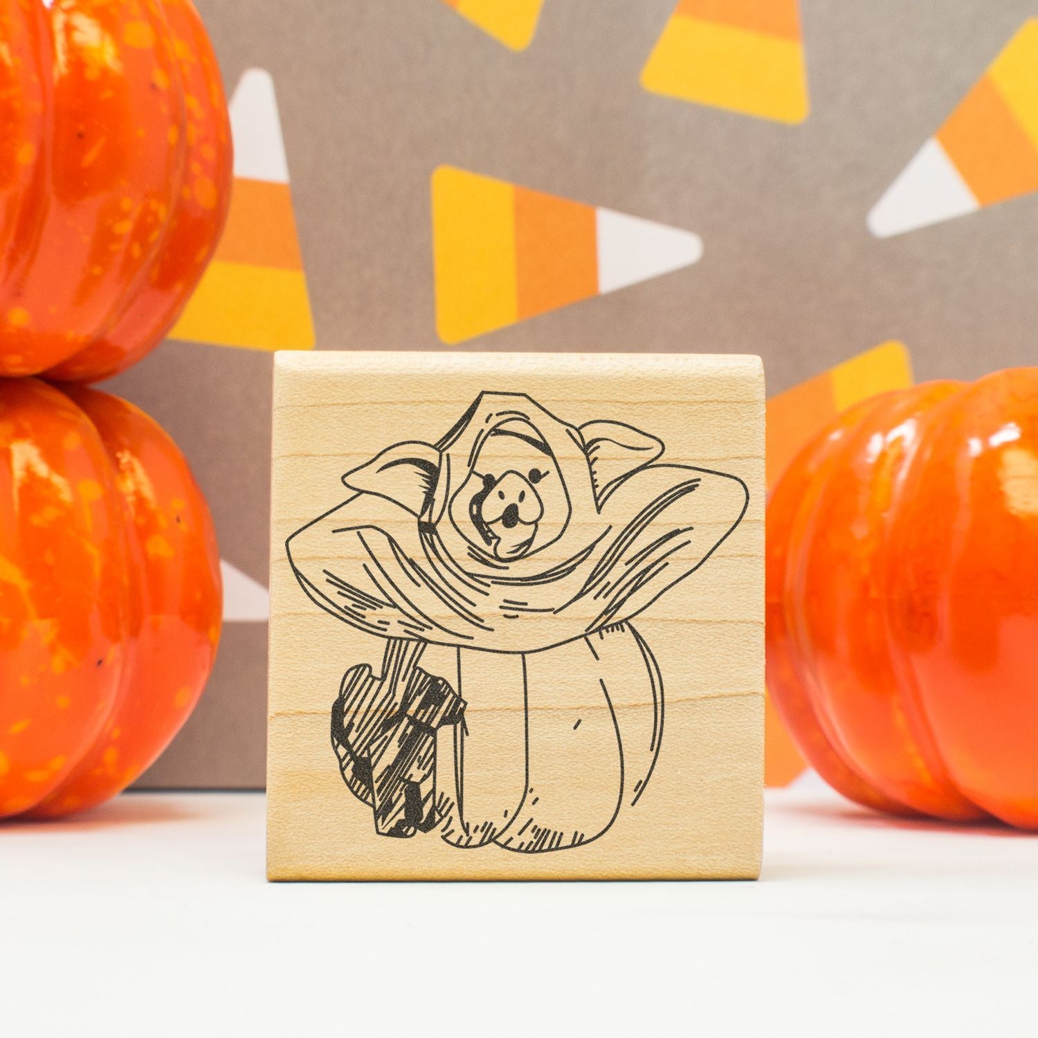 Halloween wooden stamp with a cute ghost dog design, surrounded by orange pumpkins and fall decor.