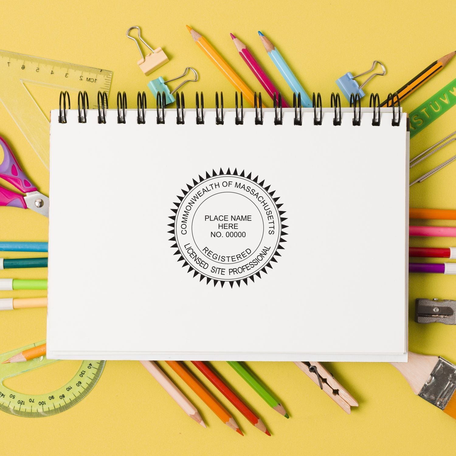 Notebook with Massachusetts licensed site professional seal surrounded by colorful school supplies on a yellow background.