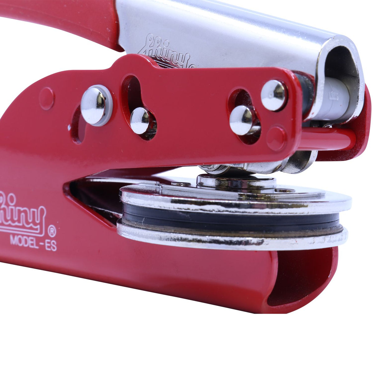 Close-up of a red and silver metal hand tool with roller mechanism, isolated on white background.