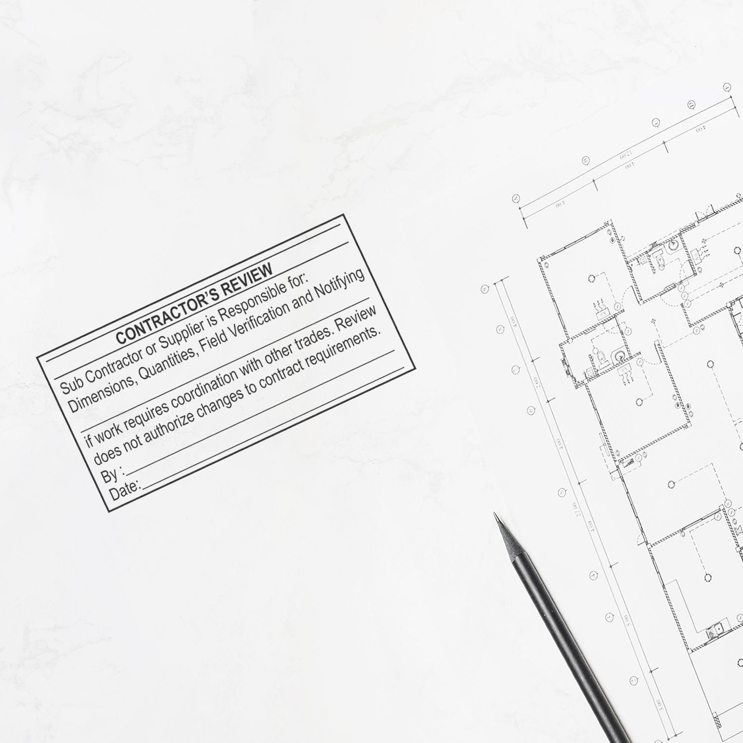 Architectural blueprint with contractors review stamp and pencil on a white drafting background.