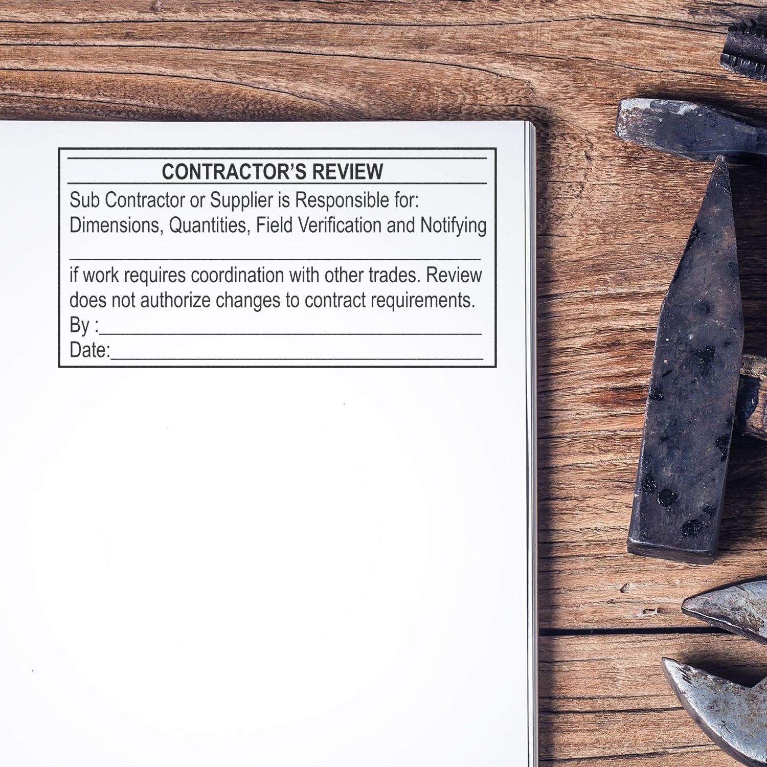 Contractors review form on a rustic wooden table with metal construction tools and supply verification document.