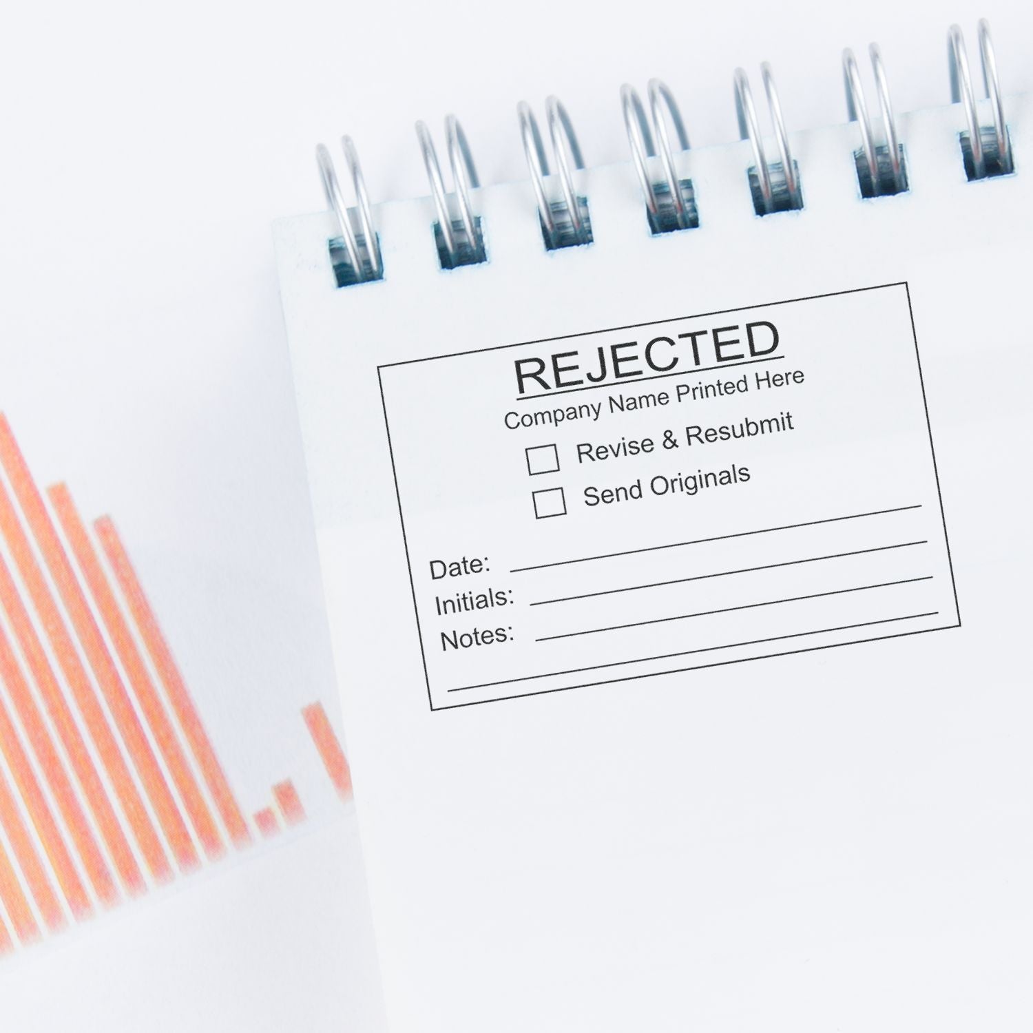 Rejected business report in a spiral notebook with charts, symbolizing failed review, revision, and resubmission.