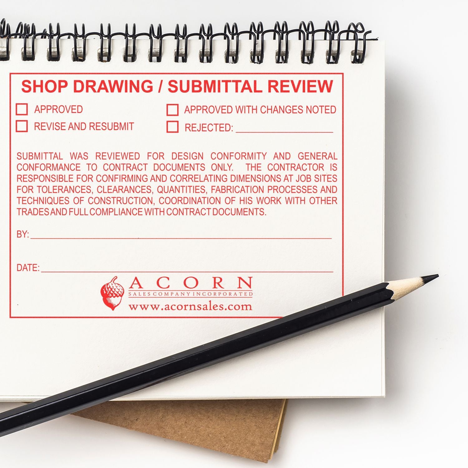 Shop drawing submittal review form in a spiral notebook with pencil, construction project approval document.