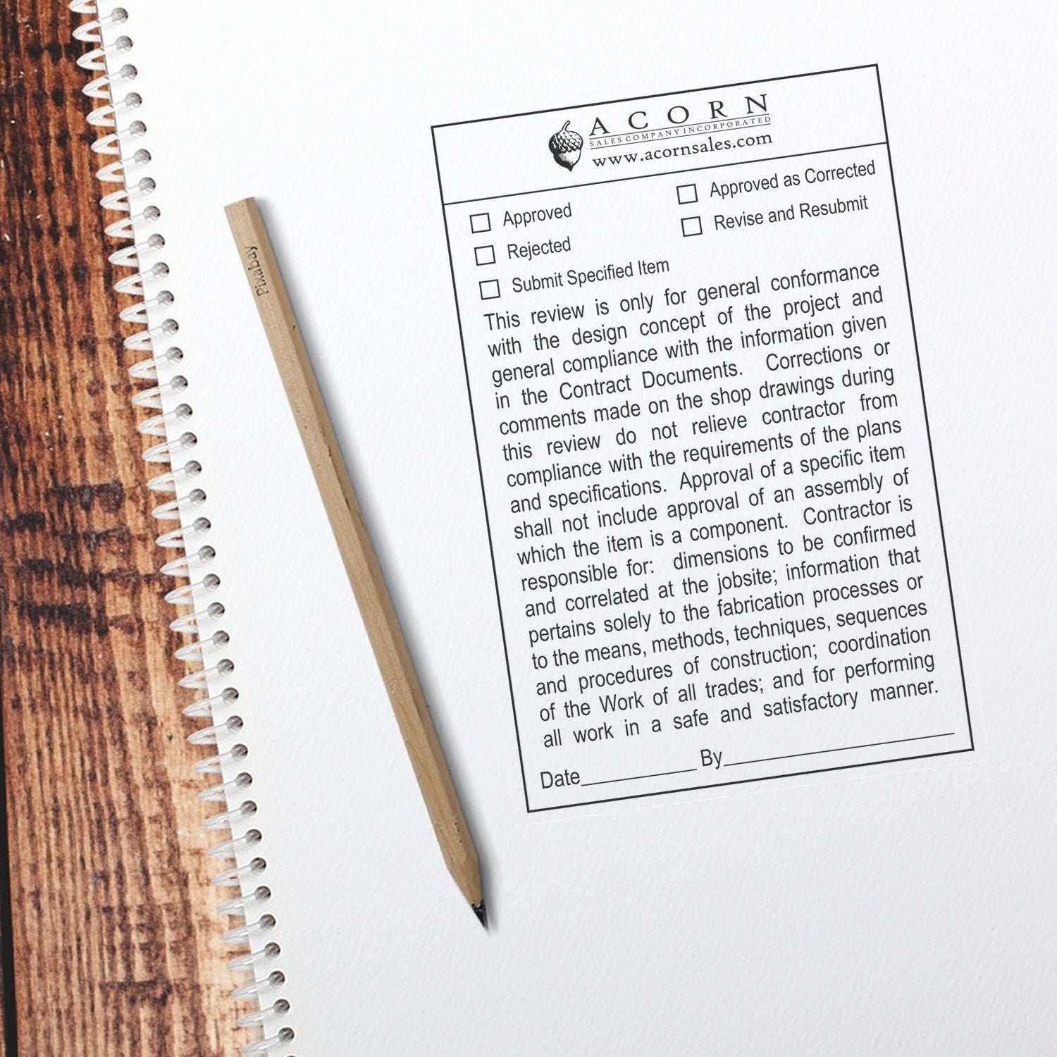 Top view of a spiral notebook with pencil and architectural approval form on a wooden desk.