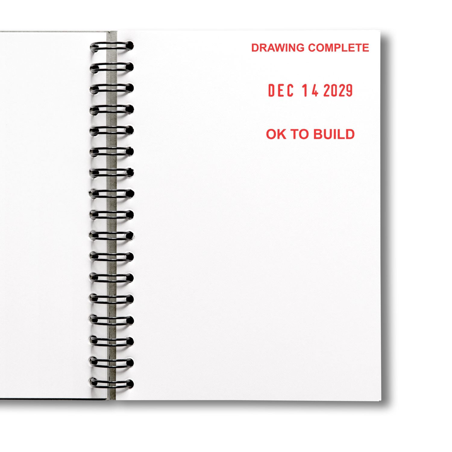 Open spiral notebook page stamped Drawing Complete, Dec 14 2029, and OK to Build in red text, symbolizing approved architectural plans.