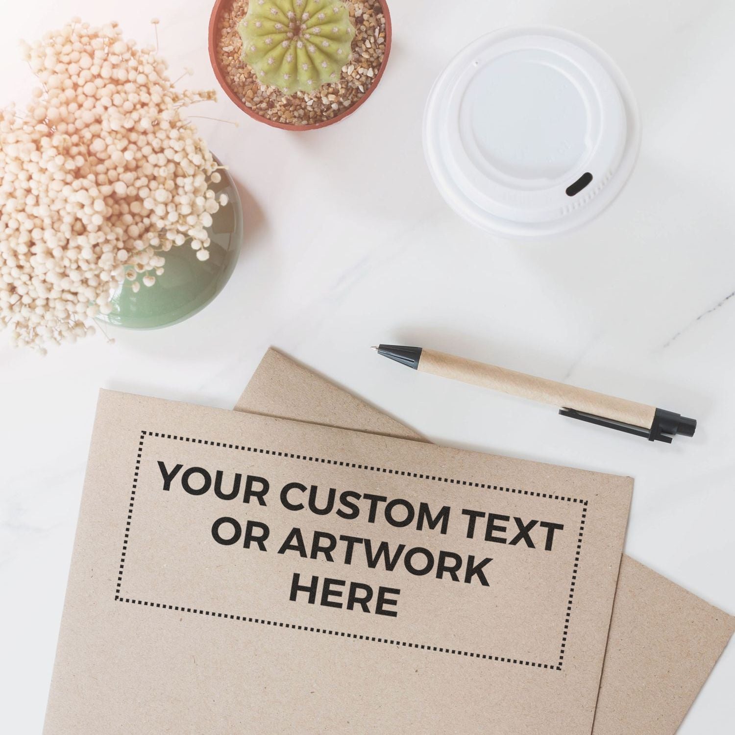 Kraft envelope mockup for custom text or artwork, flat lay with marker pen, cactus succulent and stones on clean white background.