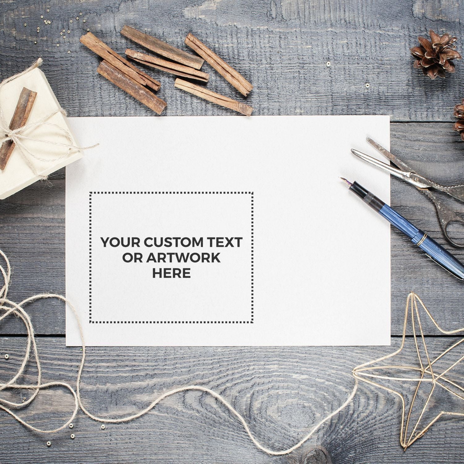 Custom artwork card mockup on rustic blue wood with stationery supplies, pen, scissors, twine, pinecones, and placeholder text.