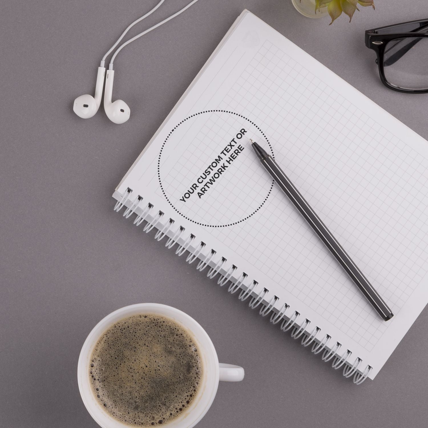 Flat-lay notebook mockup with custom text area, pen and earbudsideal for branding, stationery, and creative workspace designs.