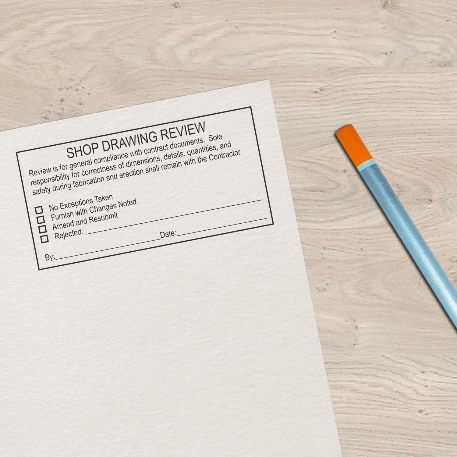 Shop drawing review form with pencil on wooden desk, construction document approval checklist.