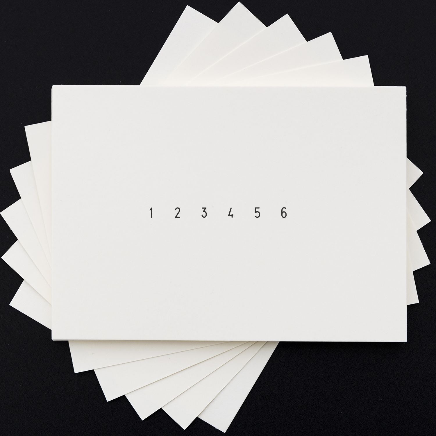 Minimalist white paper swatch stack labeled 1 through 6 on a black background.