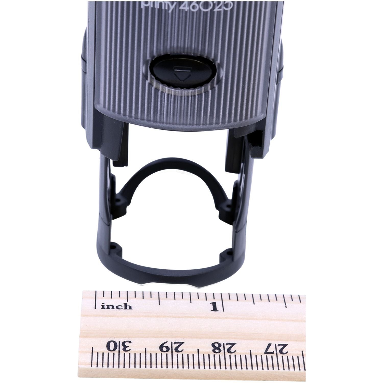 Close-up of an adjustable black plastic clamp with inch ruler for size reference on a white background