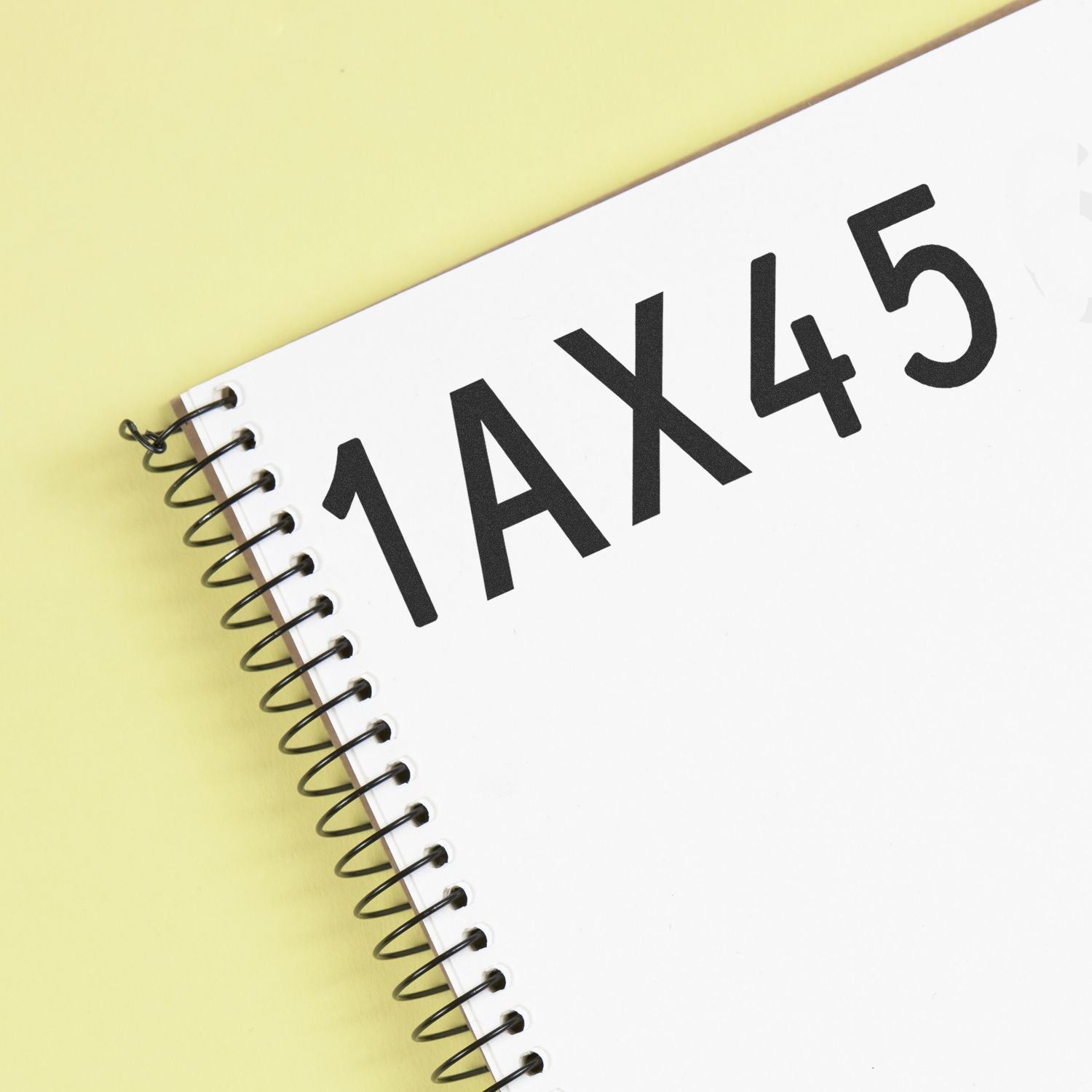 Spiral notebook with bold 1AX45 text on a yellow background.