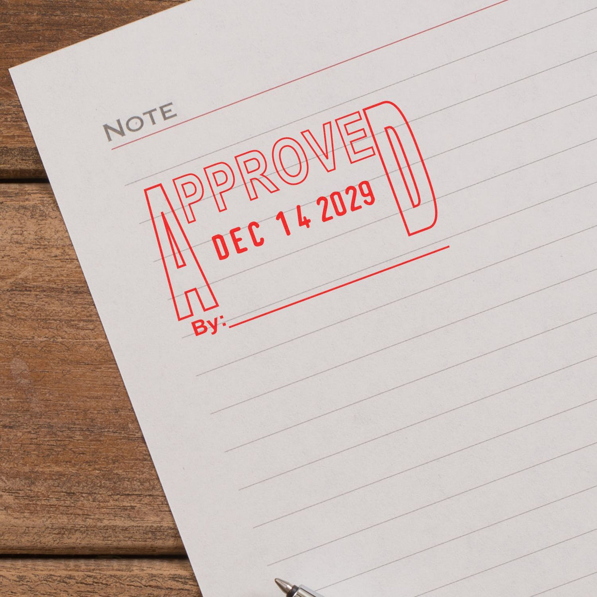 Approved stamp on lined note paper on a wooden desk, business document approval concept.