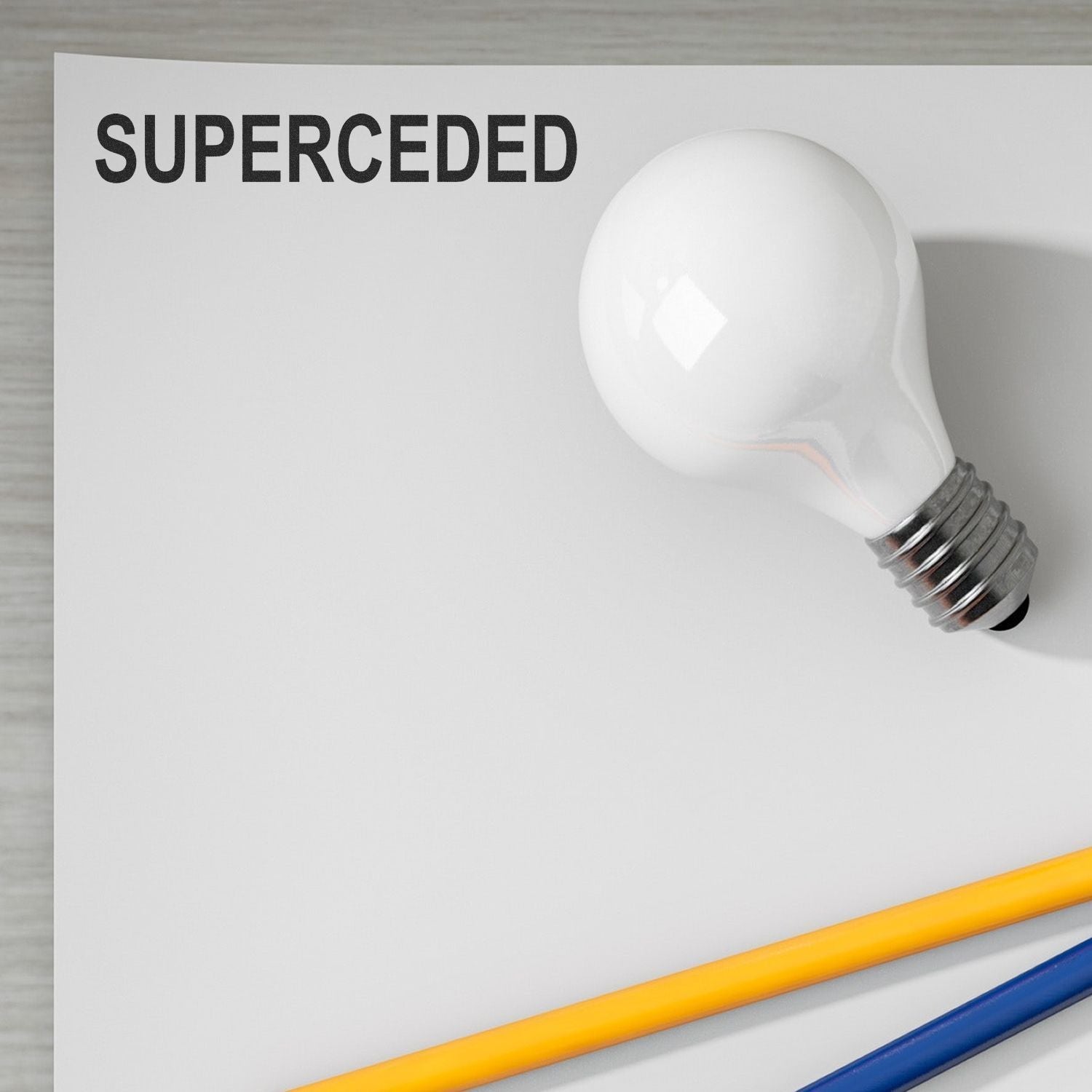 Light bulb with SUPERCEDED text on blank paper, symbolizing replacement or obsolete ideas.
