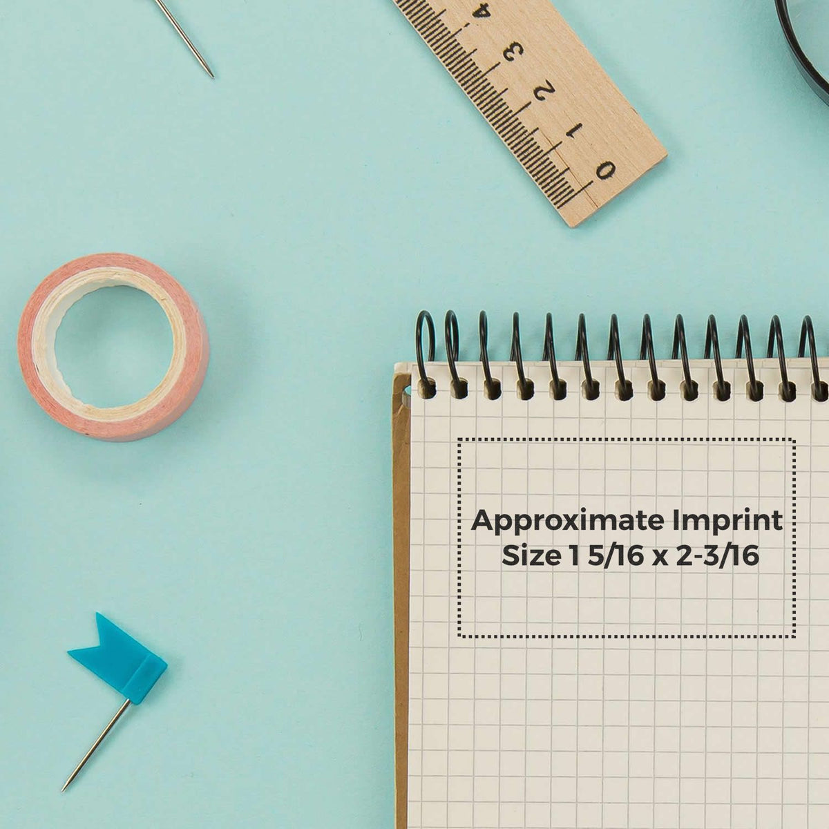Ruler, pins and tape measure show approximate imprint size 1 5/16 x 2-3/16 for accurate crafting design sizing.