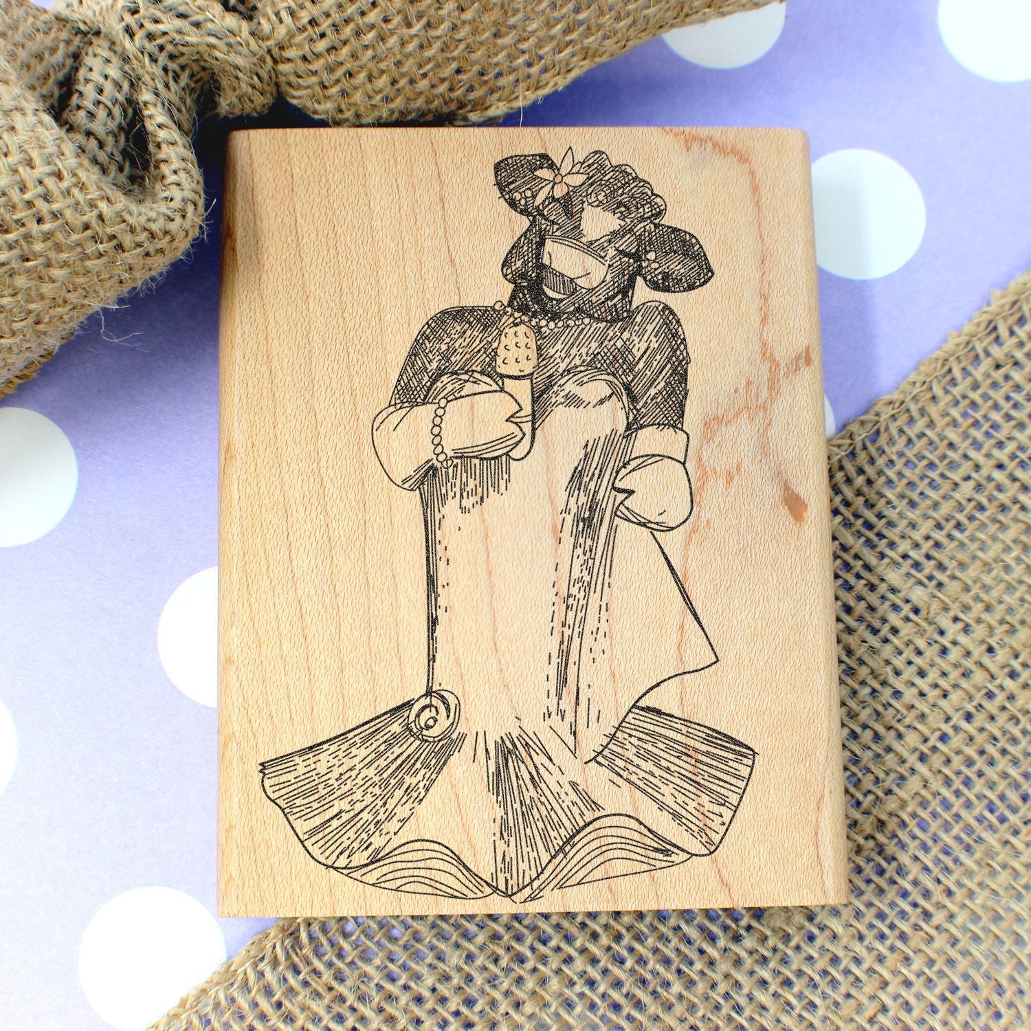 Wooden stamp block with engraved cowgirl mermaid illustration on a polka dot background.