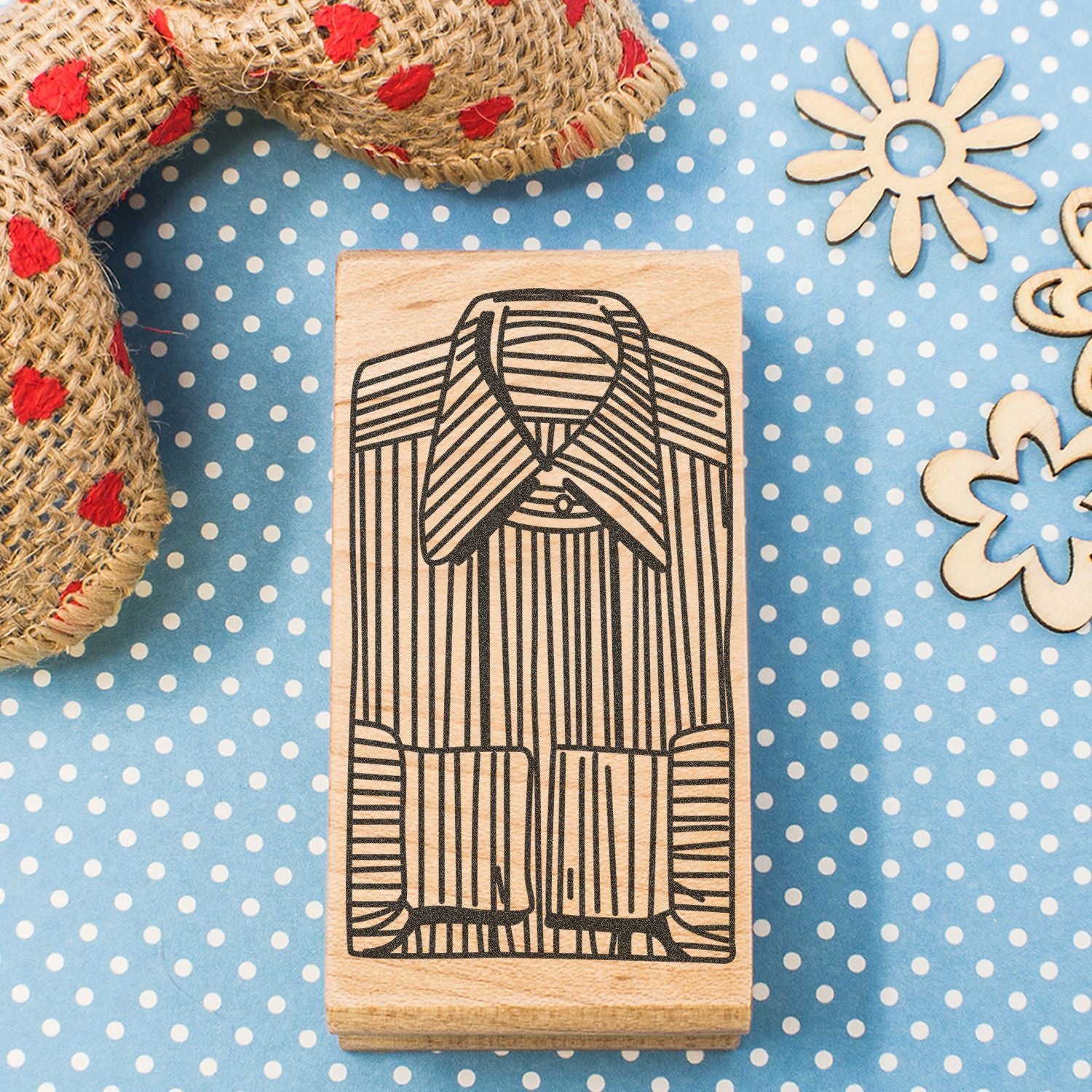 Wooden rubber stamp with striped shirt design on blue polka dot craft background with burlap ribbon and wooden flower embellishments