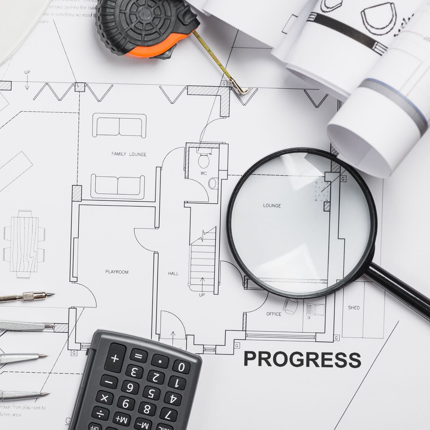 Architectural floor plan with tape measure, magnifying glass, calculator, and blueprints for home renovation progress.