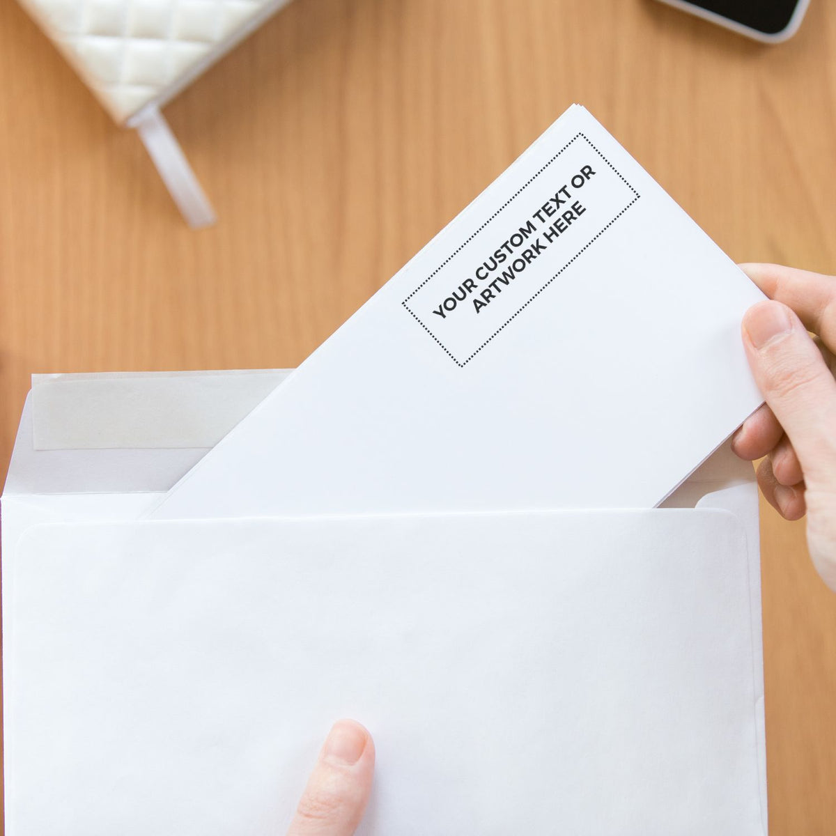 Hand holding mailer with custom label Your custom text or artwork here, showcasing branded packaging and personalized artwork placement.