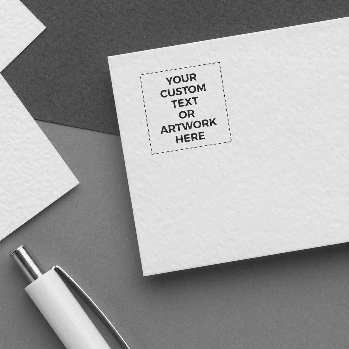 Custom stationery mockup showing Your Custom Text or Artwork Here on white card with pen and layered paper for branding