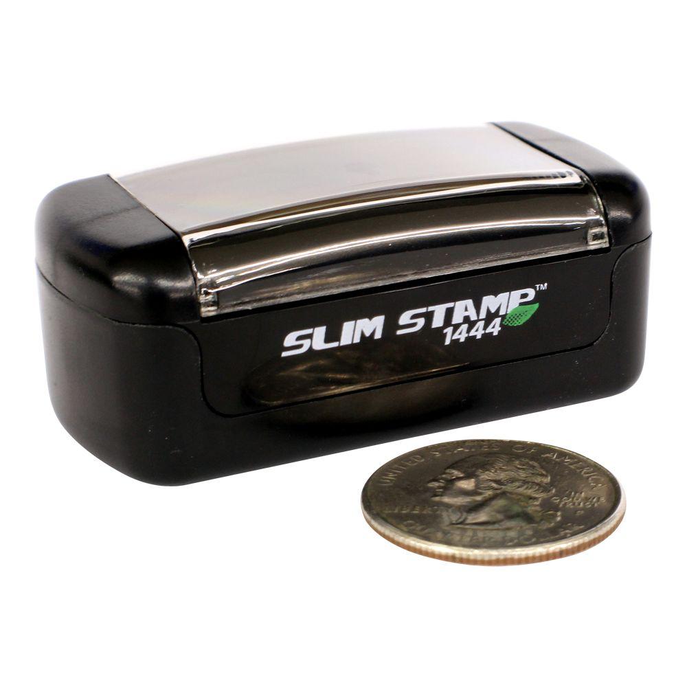 Slim Stamp 1444 compact black self-inking stamp with coin for size reference.