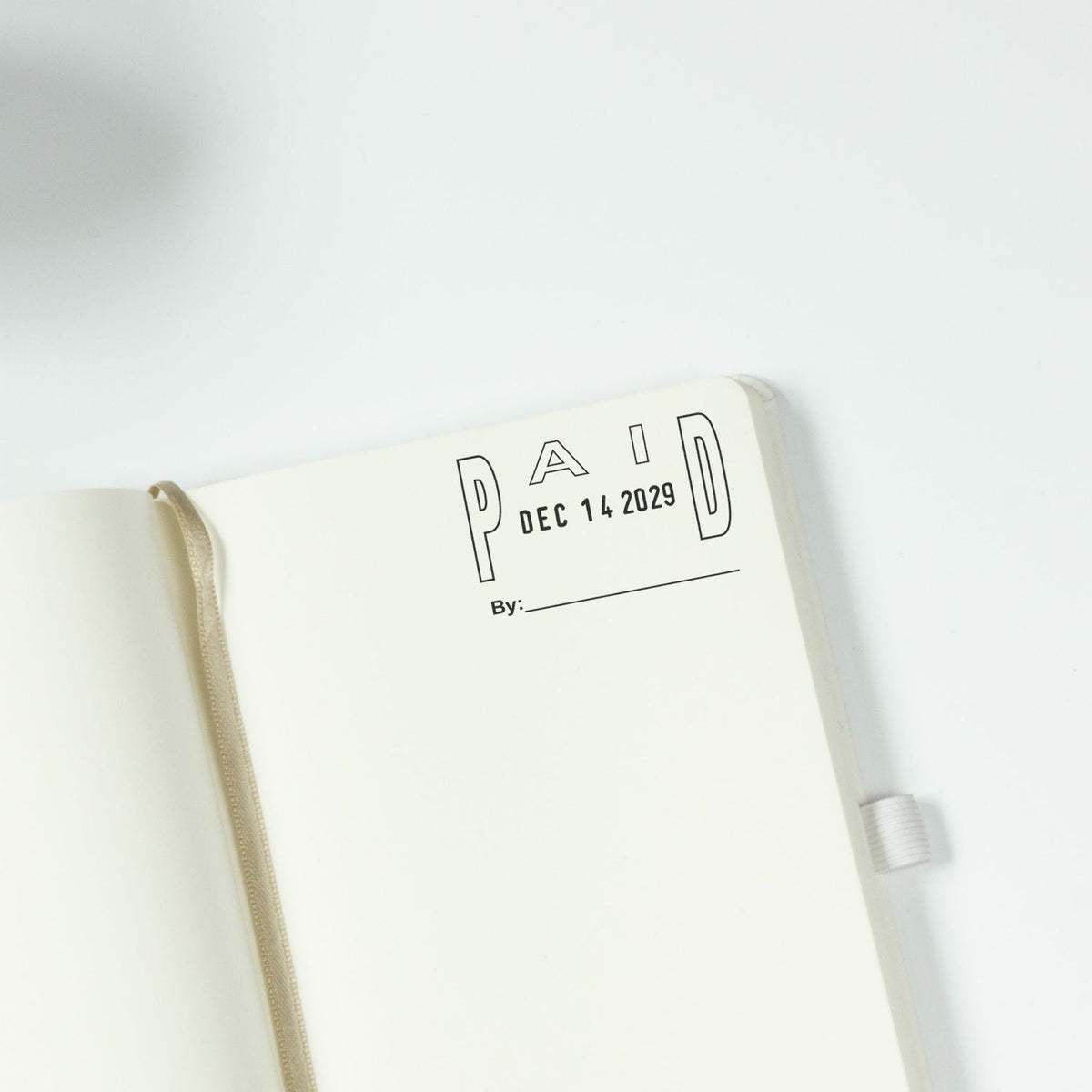 Open minimalist notebook page with PAID stamp, December 14, 2029 date, and signature line on a white background.