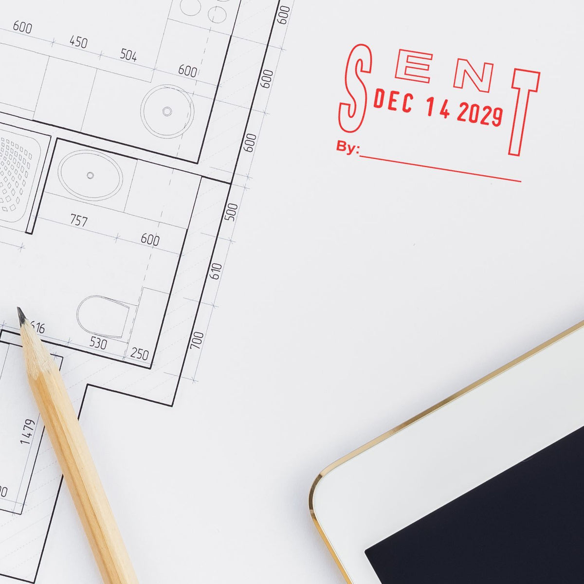 Architectural floor plan sketch with pencil, tablet, and red sent stamp on blueprint design document