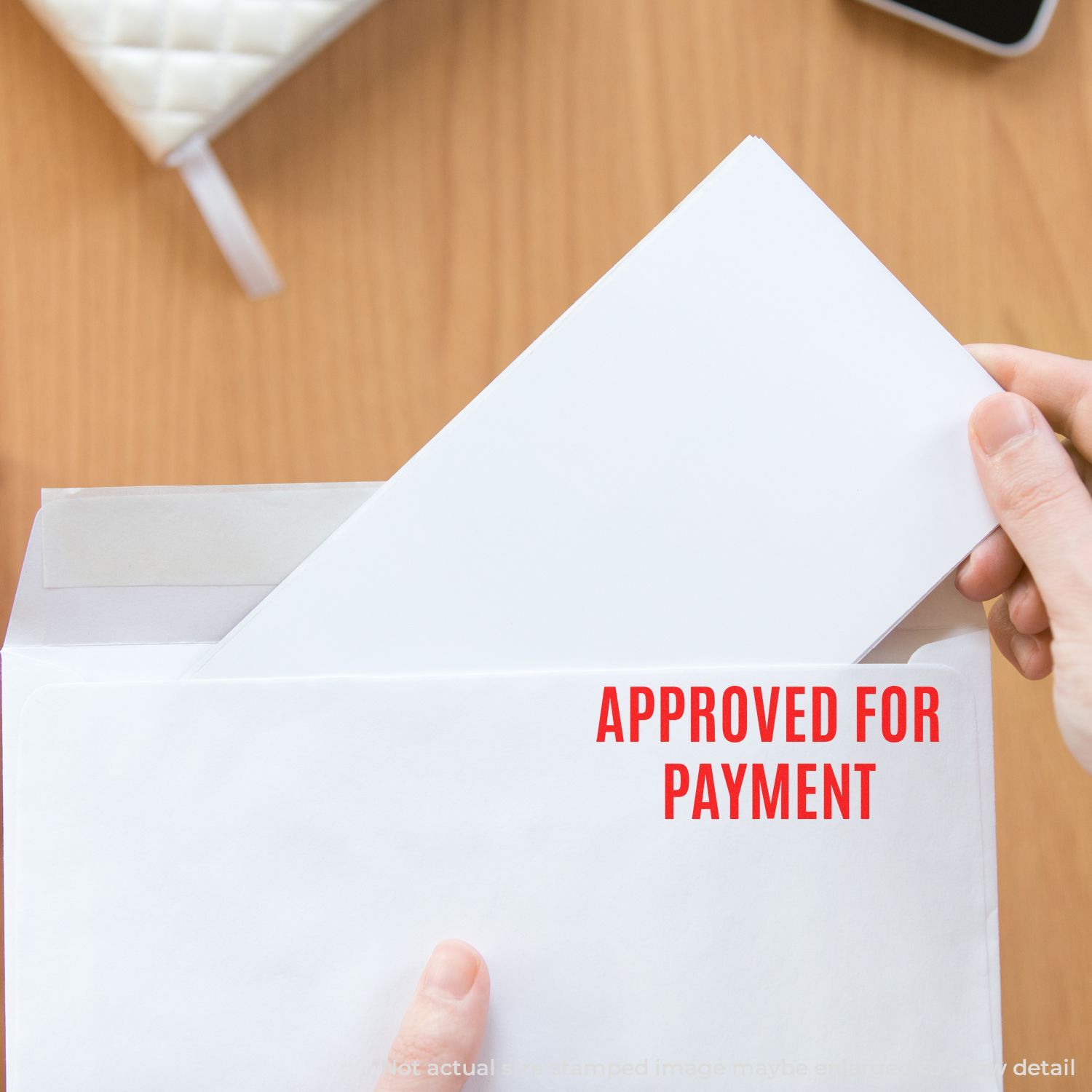 Hand holding an invoice marked Approved for Payment, showing authorized billing and payment processing in office