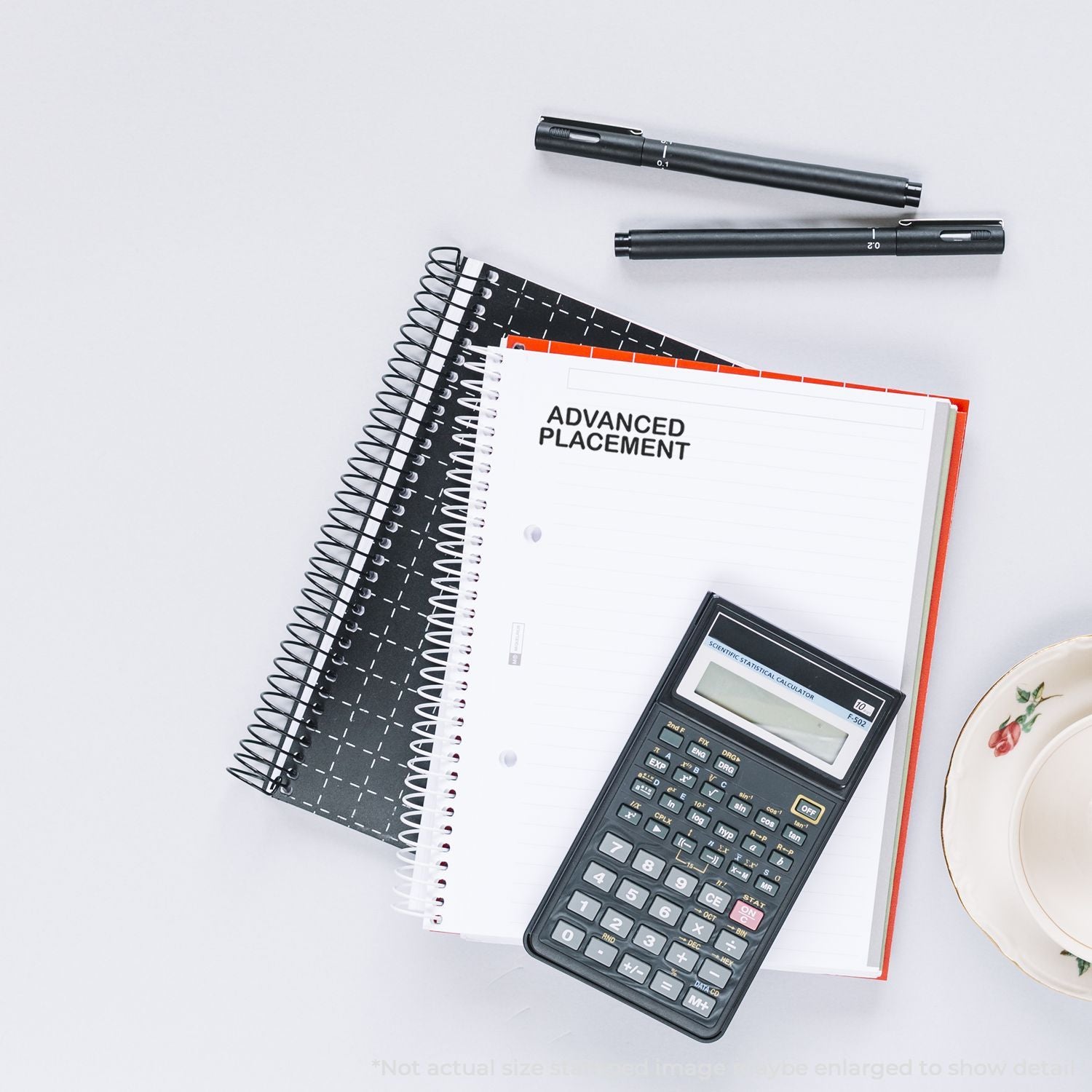 Advanced Placement study setup with scientific calculator, pens, and notebookmath and science test preparation tools.