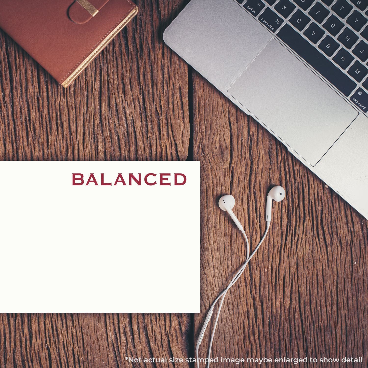 Balanced note card on a desk with earbuds and laptop, symbolizing financial planning, budgeting, and productivity tracking.
