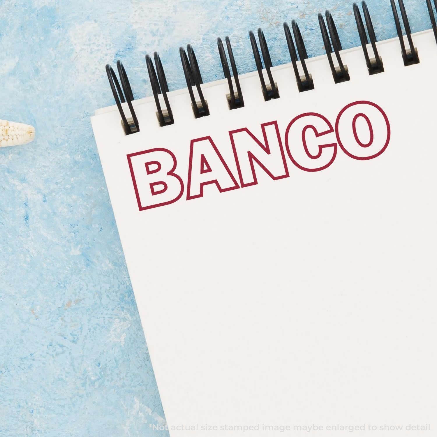 Close-up of a spiral notebook with the word BANCO on a blue textured background.