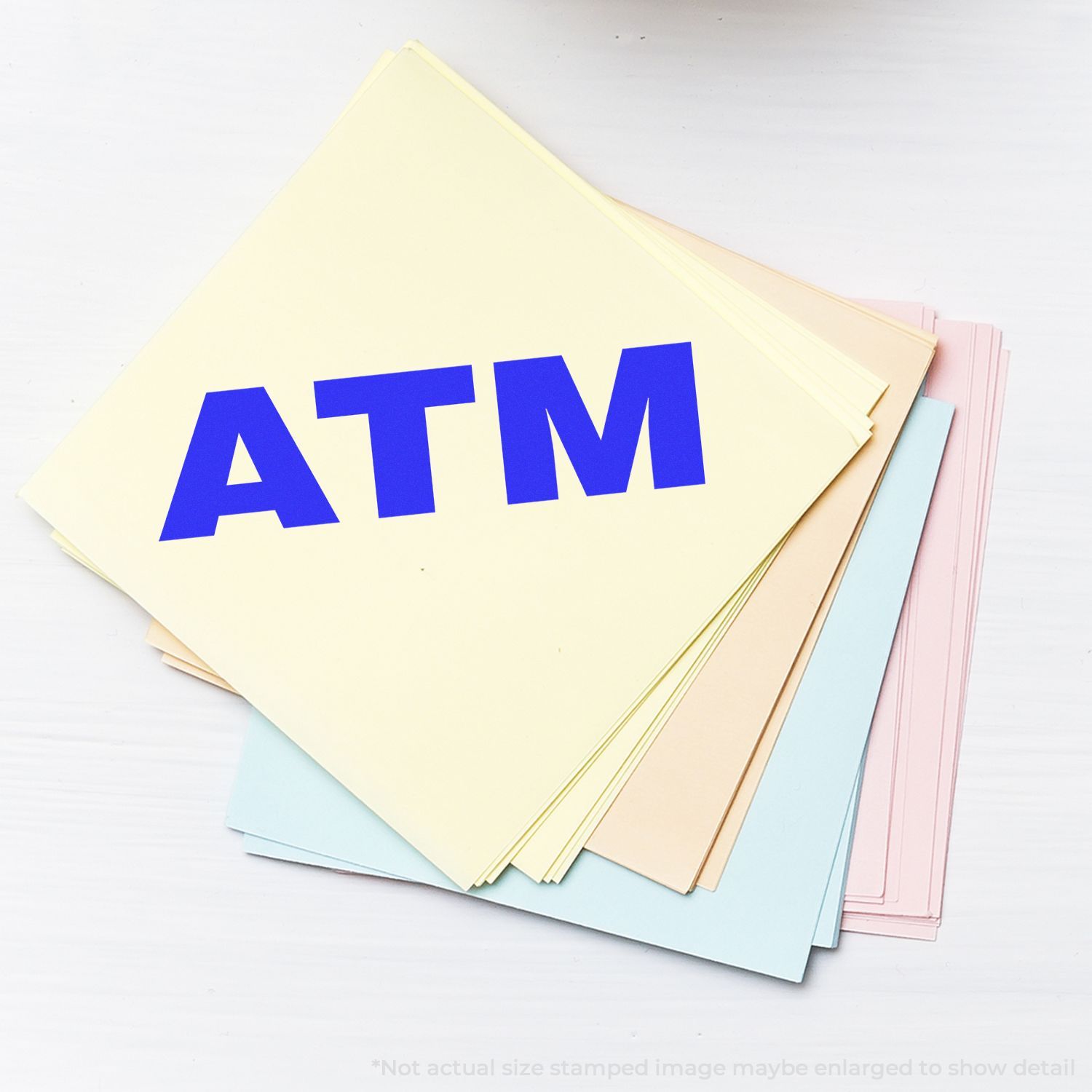 Stack of pastel colored paper sheets with bold blue ATM lettering, office stationery document set