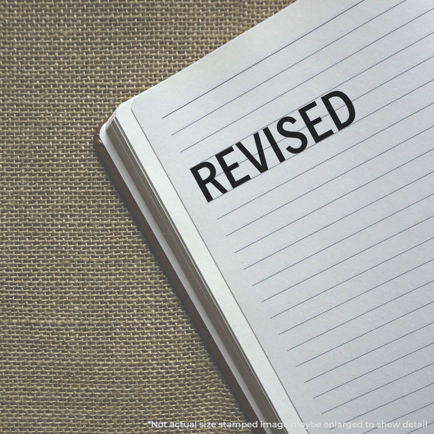 Revised stamp on lined notebook paper for document editing, proofreading, and update confirmation.