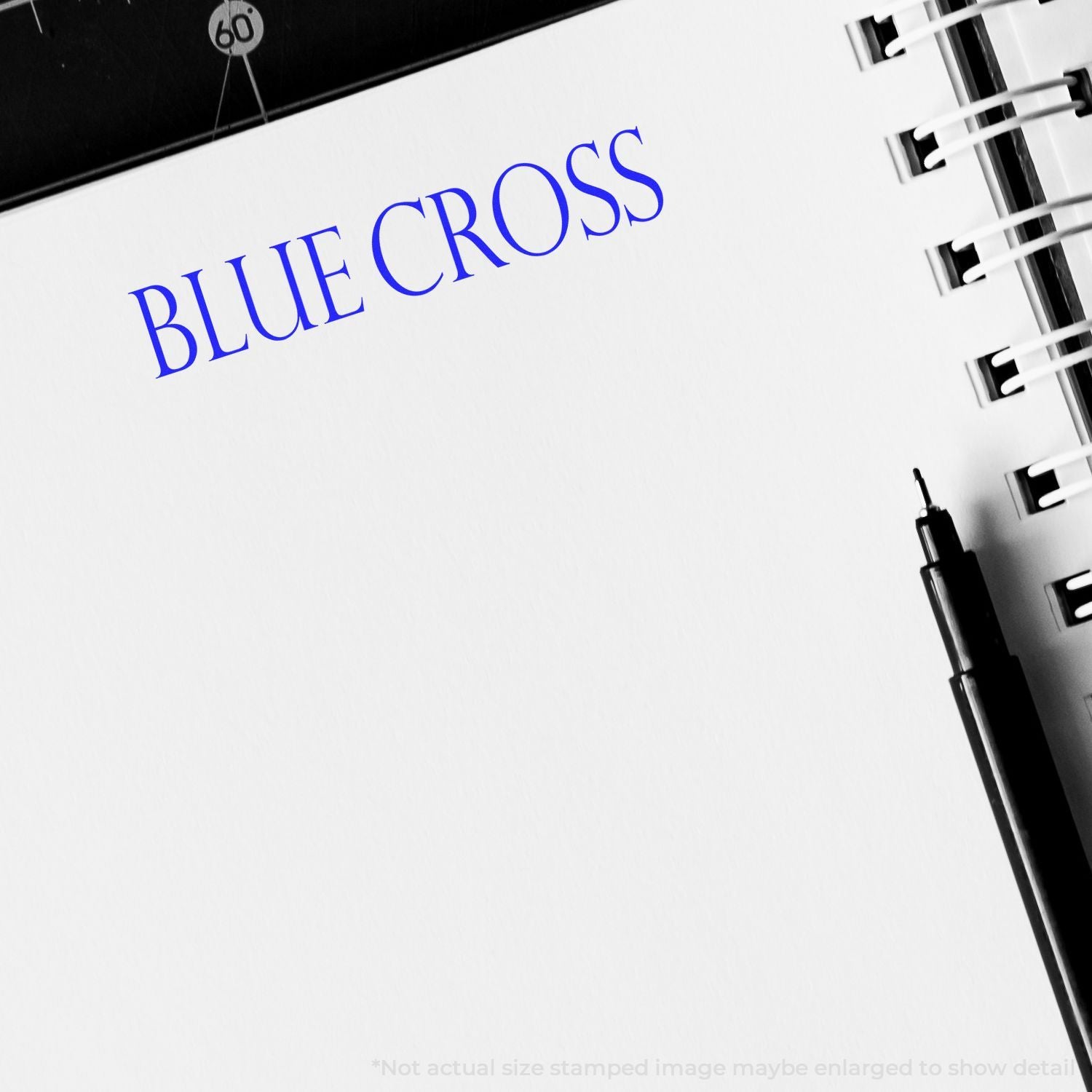 Blue Cross sign with blue lettering on a building exterior, branded health insurance signage beside street pole.