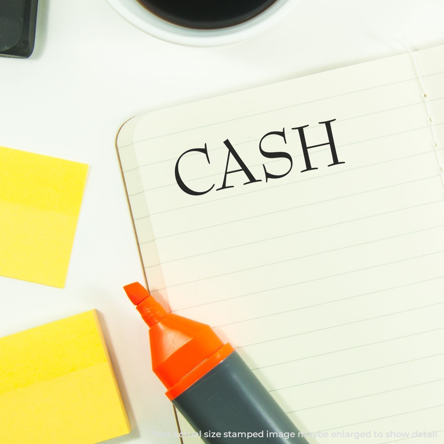 Cash written in notebook with marker, sticky notes, and office desk supplies for budgeting and financial planning.