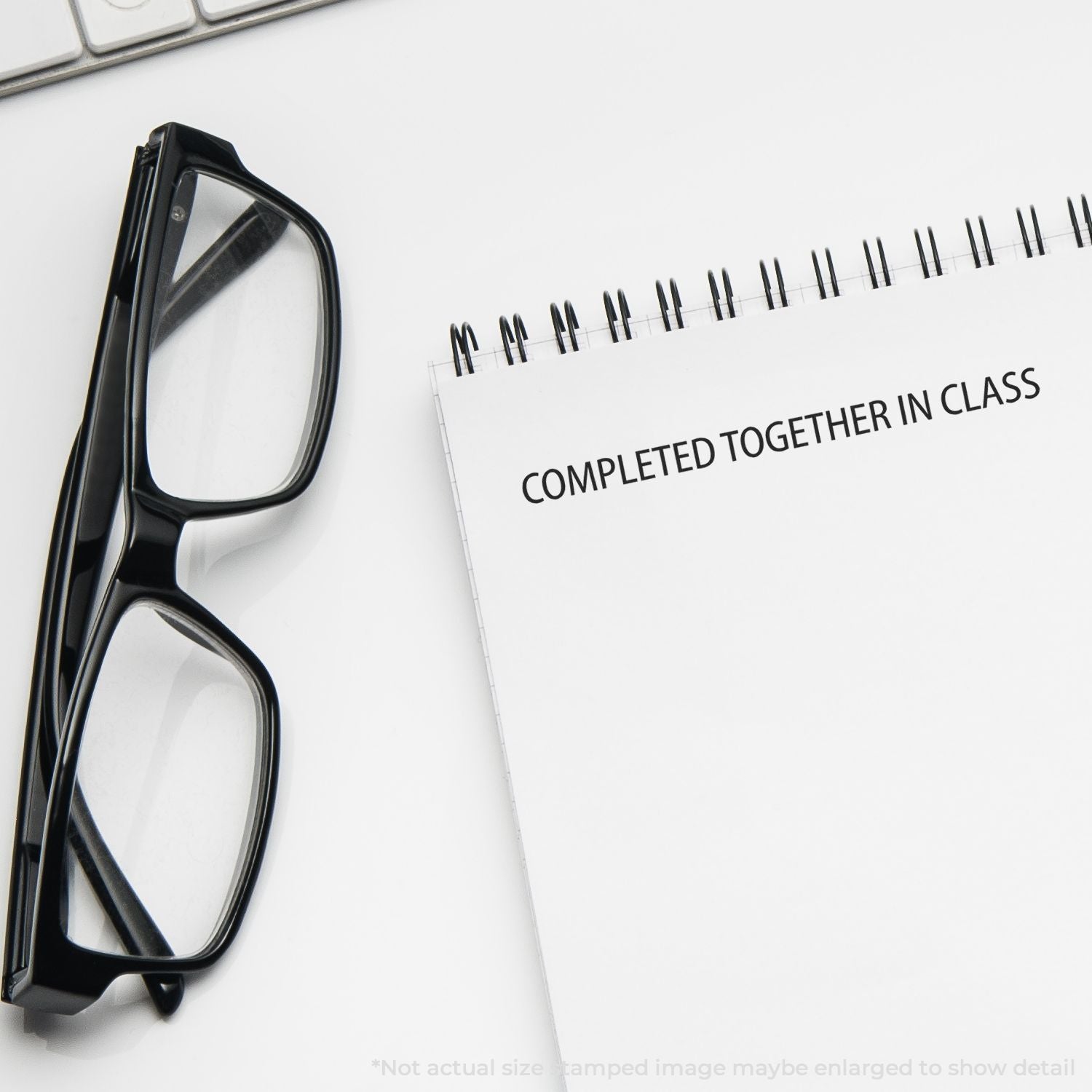 Black eyeglasses beside notes reading COMPLETED TOGETHER IN CLASS, highlighting collaborative classroom learning and study.