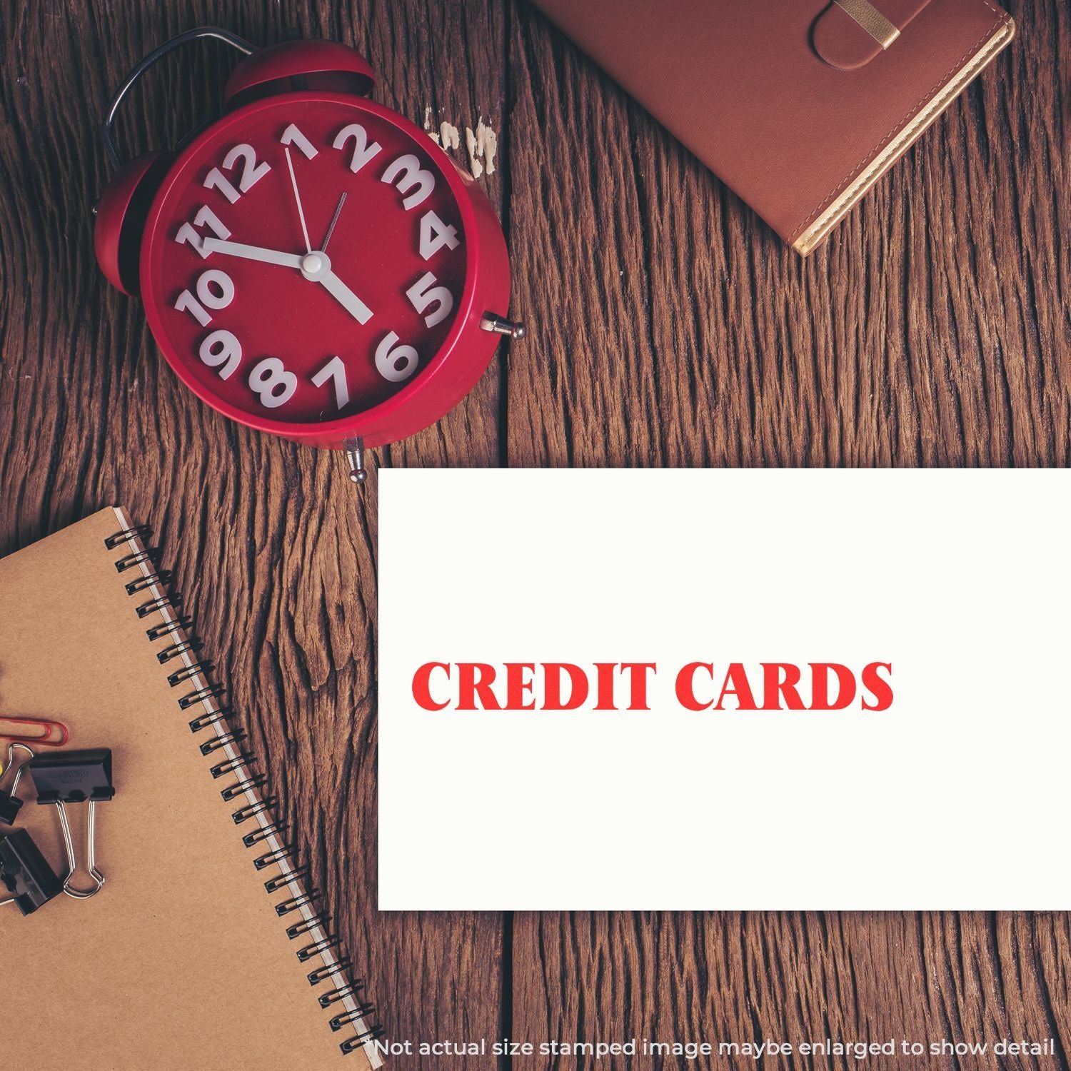Credit cards concept: red alarm clock, wallet and notebook on wooden desk with CREDIT CARDS, payment reminder theme