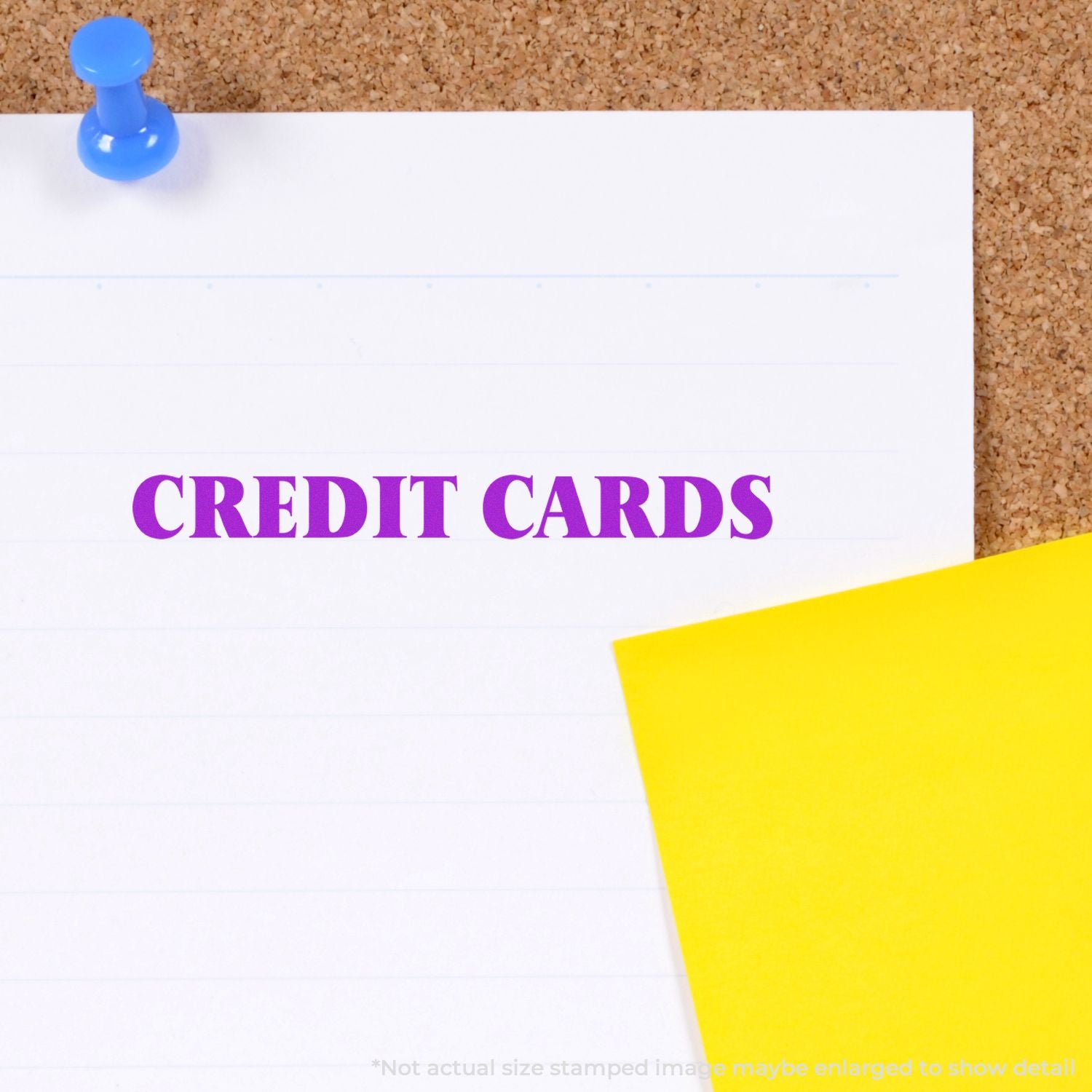 Credit cards concept note pinned on cork board with blue pushpin and yellow sticky note.