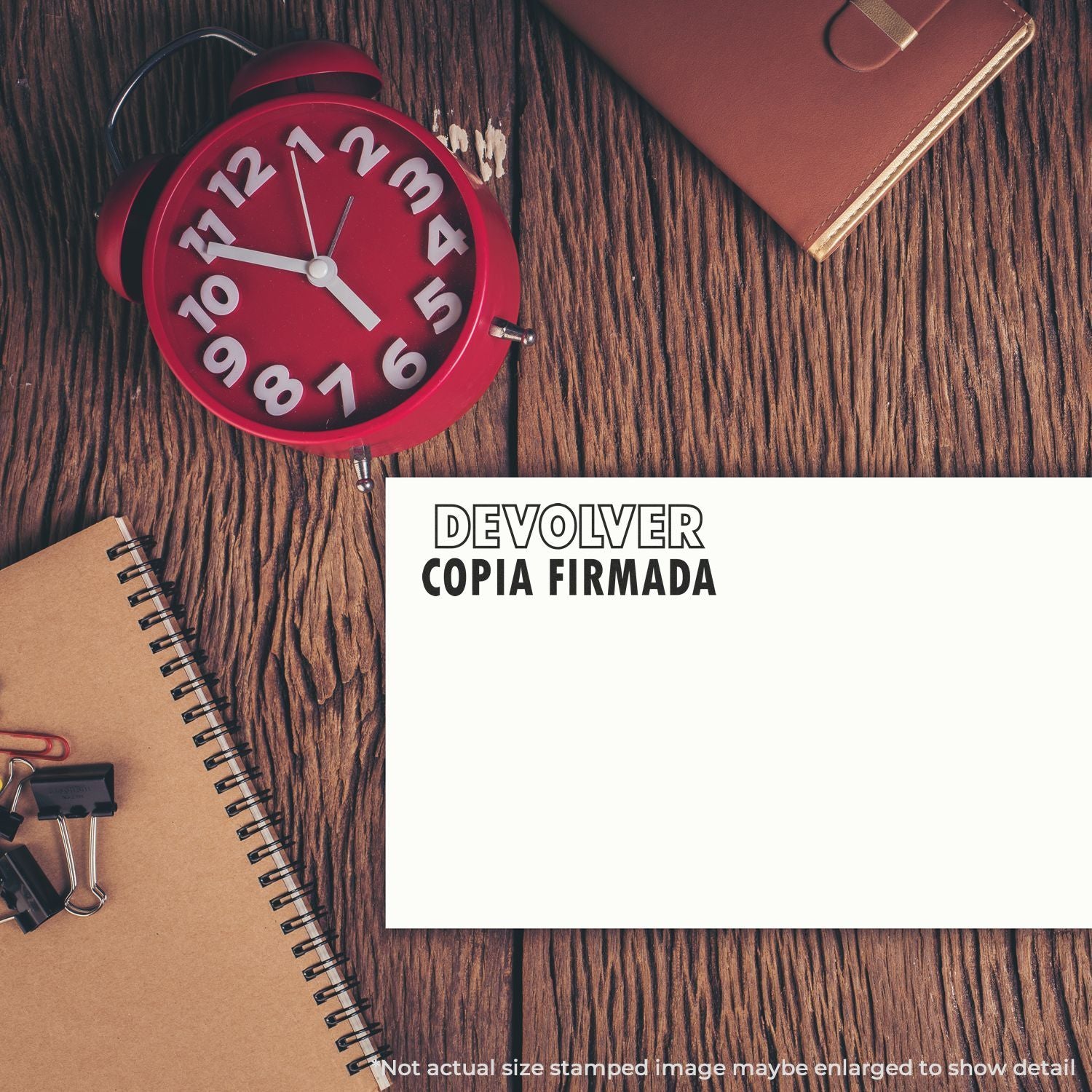 Reloj despertador y libreta sobre madera con texto Devolver copia firmada, recordatorio de plazo para documentos firmados