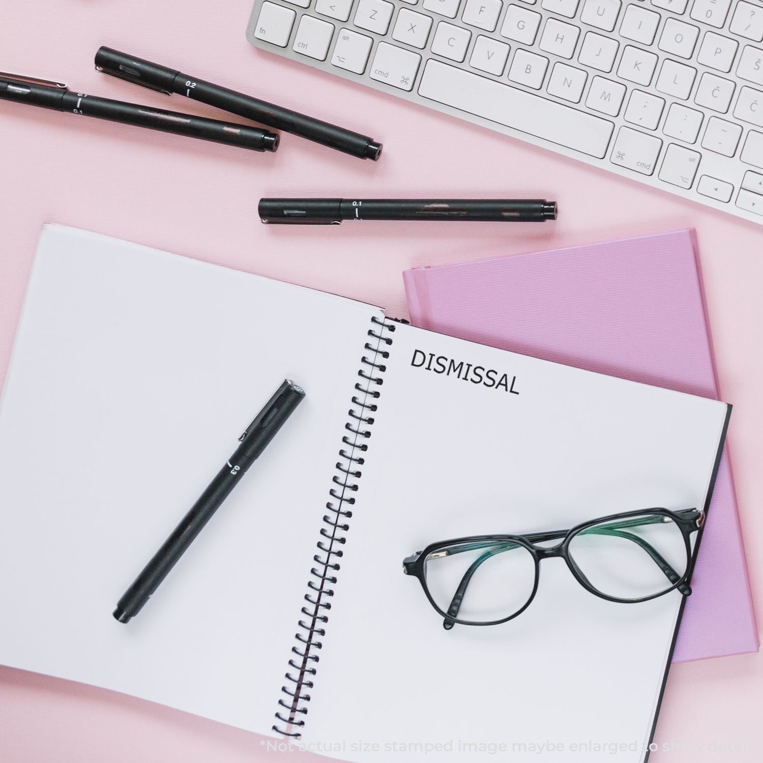 Employment dismissal paperwork concept with notebook reading DISMISSAL, pens and glasses on desk near laptop keyboard, HR legal.