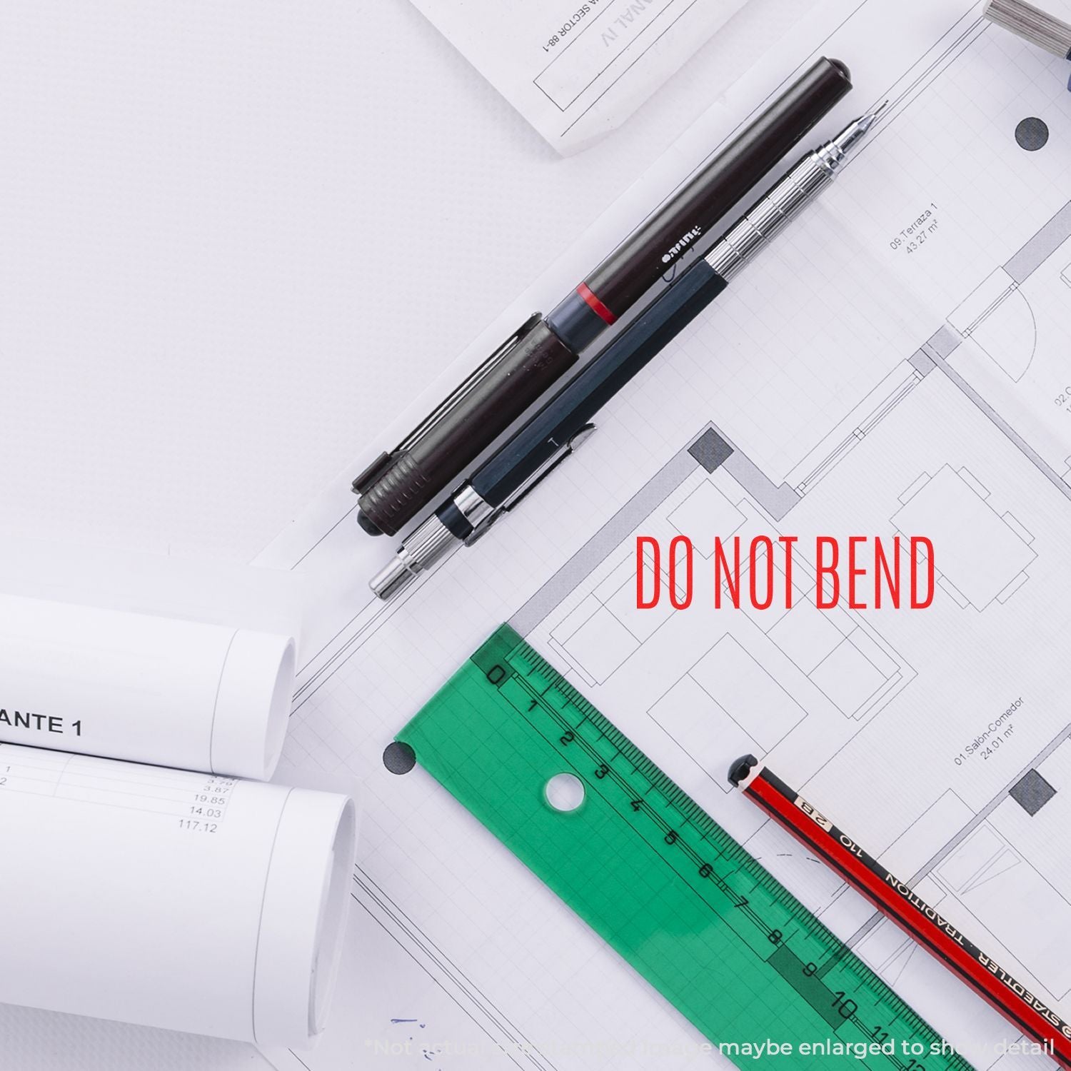 Construction blueprint with rulers and pen, marked DO NOT BENDwarning image for handling engineering drawings.