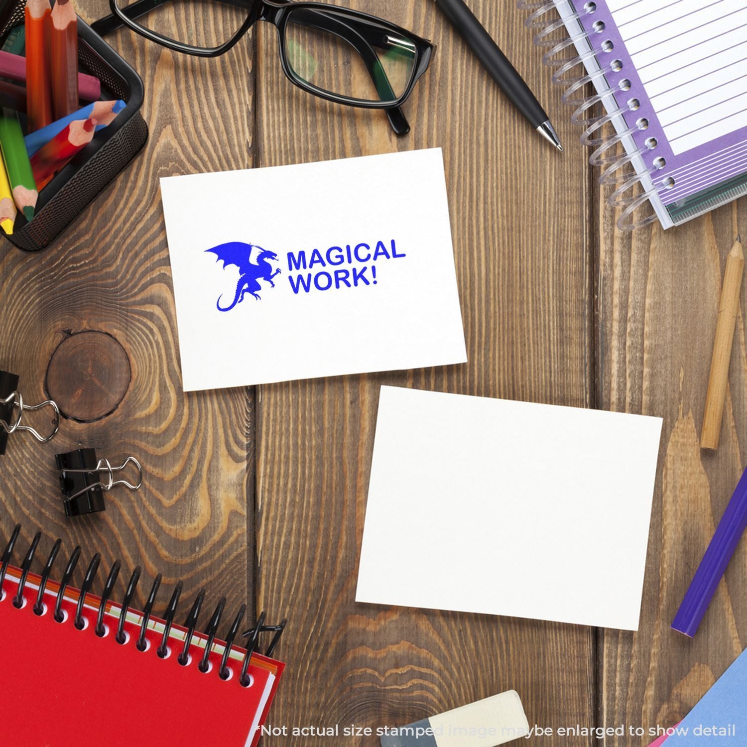 Top view of stationery on a wooden desk with glasses, pencils, notebooks, and a white card featuring a Magical Work dragon logo.