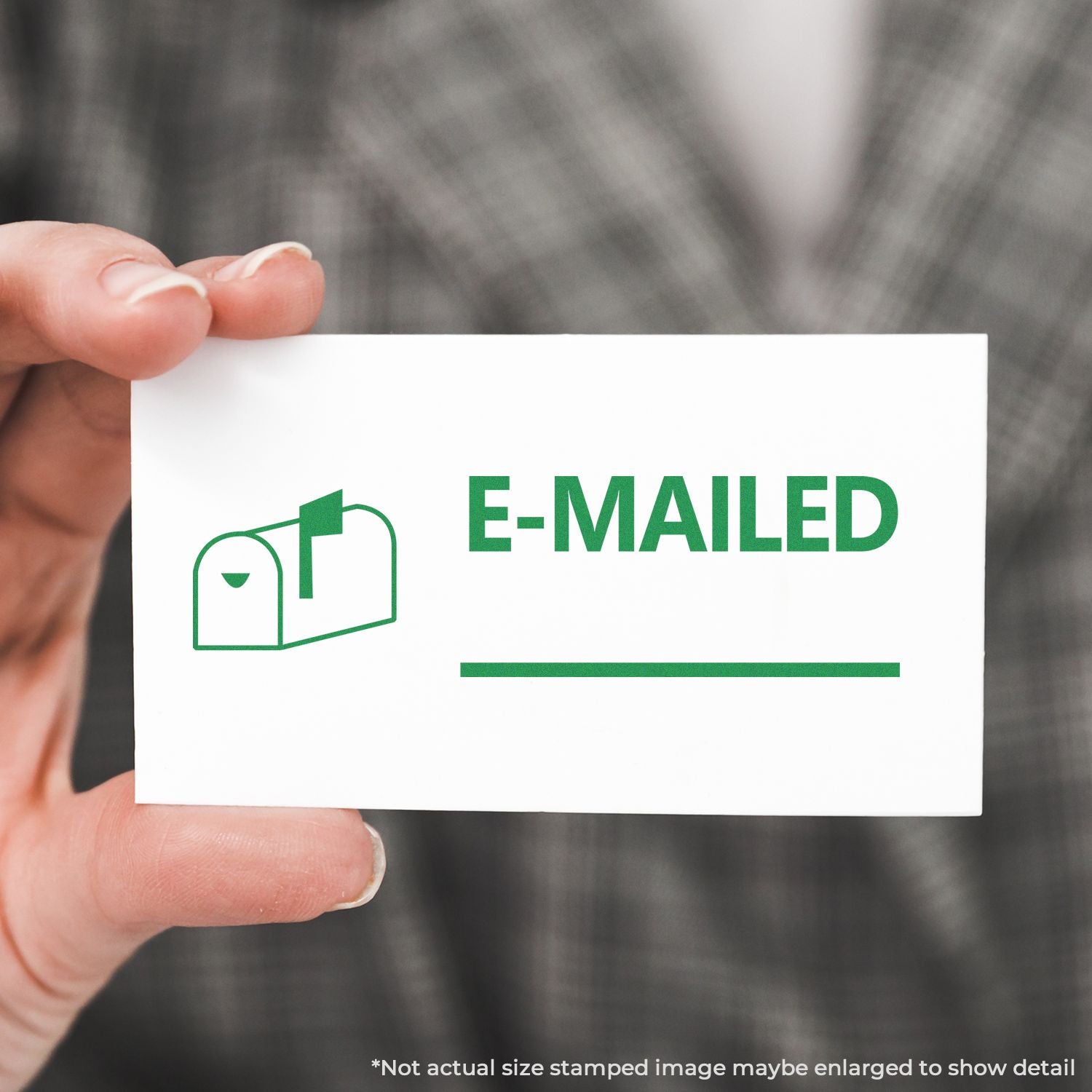 Hand holds an e-mailed notification card showing the E-MAILED email status icon, symbolizing successful email delivery.