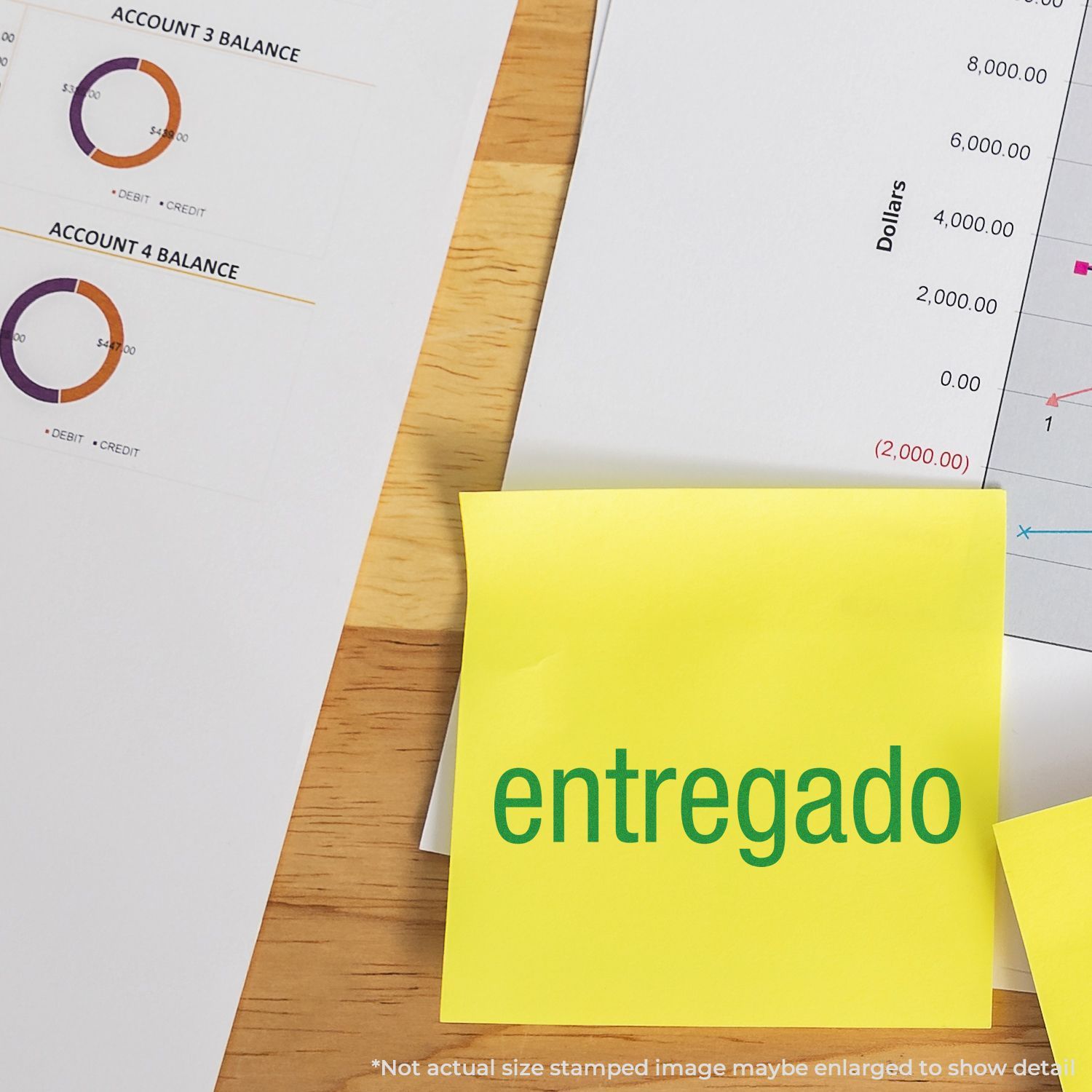 Yellow sticky note stamped entregado on financial reports and accounting charts on a wooden desk.
