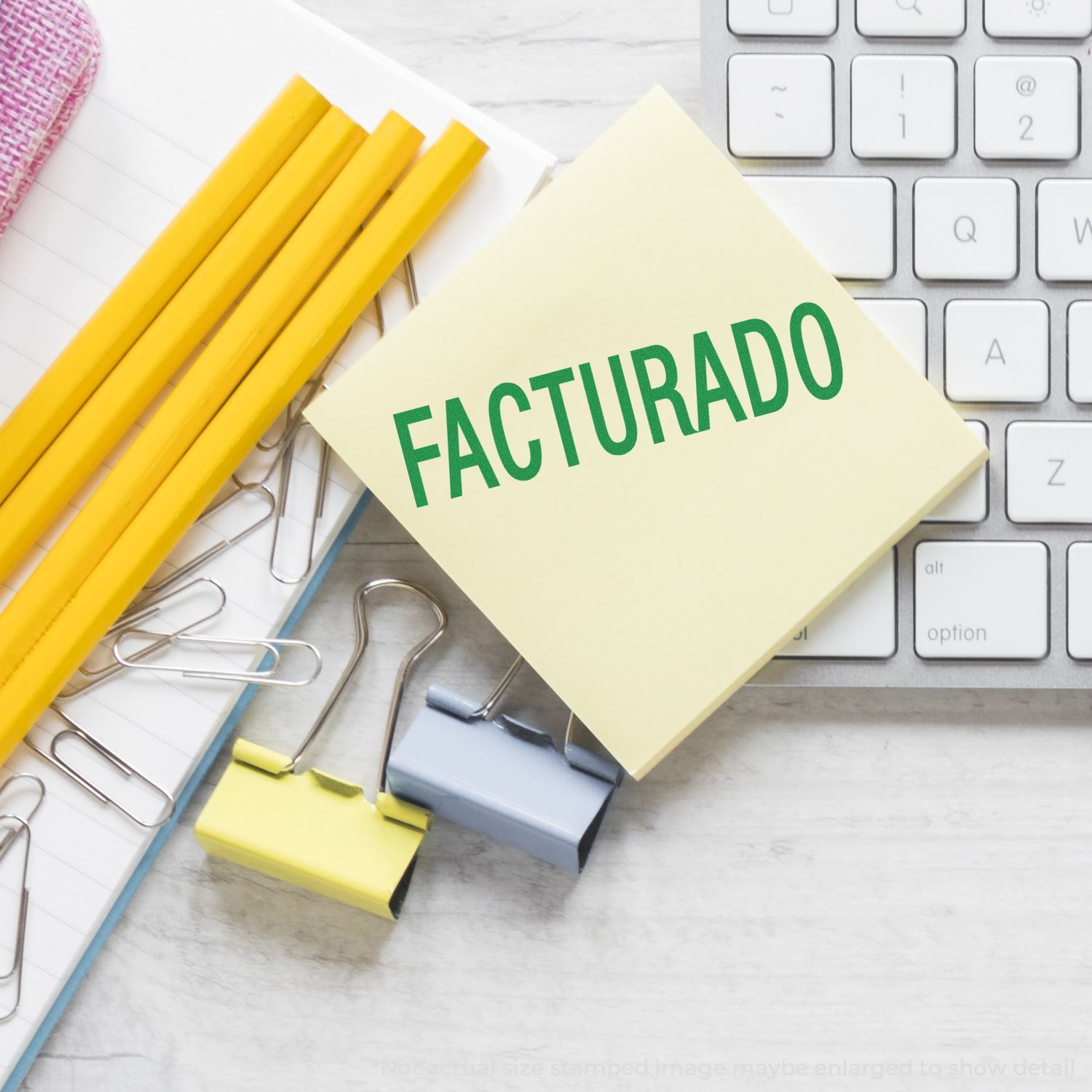 Facturado sticky note with pencils and notebook beside computer keyboard, illustrating invoicing completion and billing status.