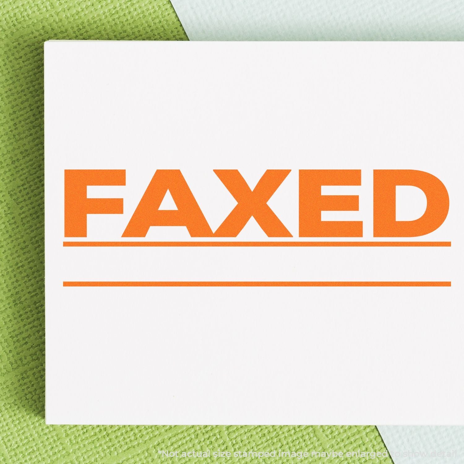 Close-up of a white document with bold orange FAXED stamp on a green textured background.