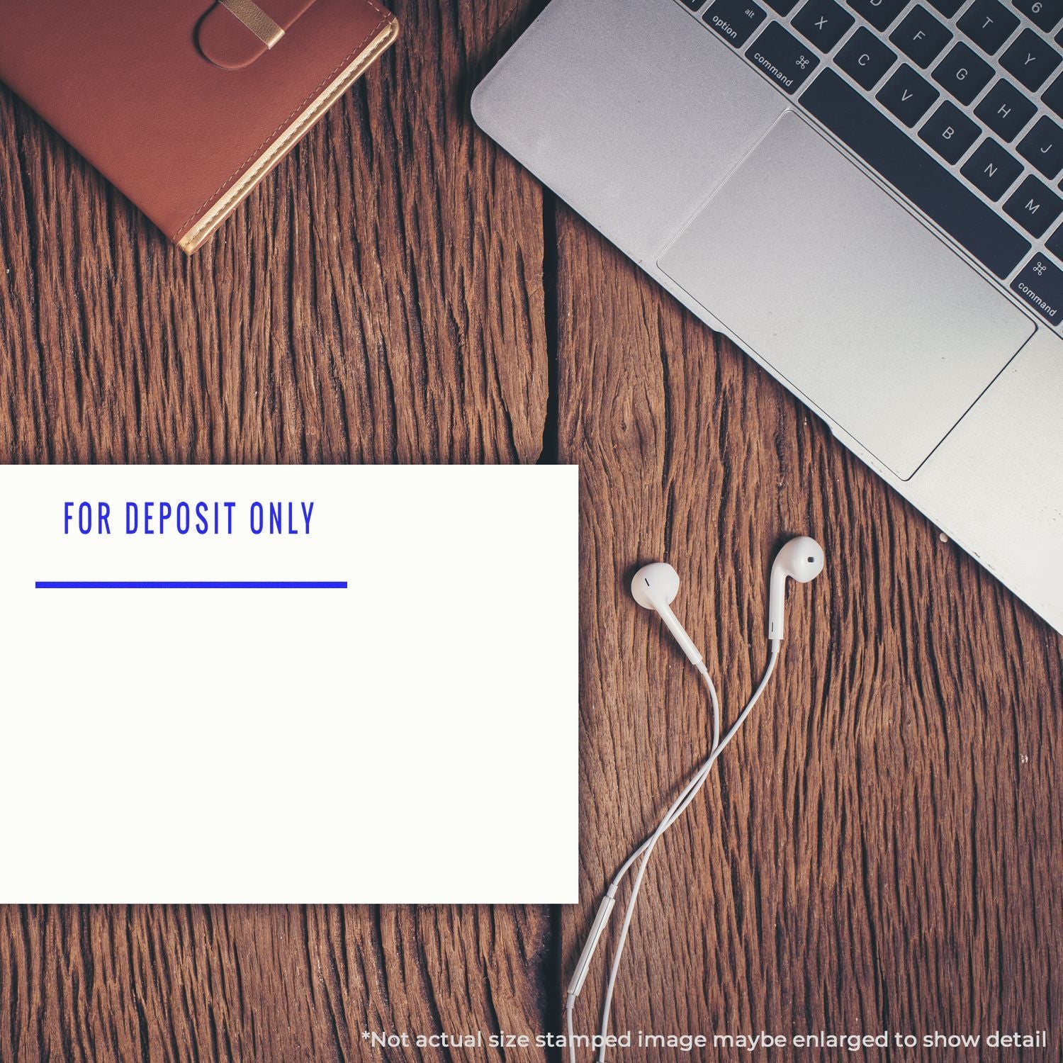 For Deposit Only check with laptop, wallet, and earbuds on a wooden desk, office banking and finance concept.