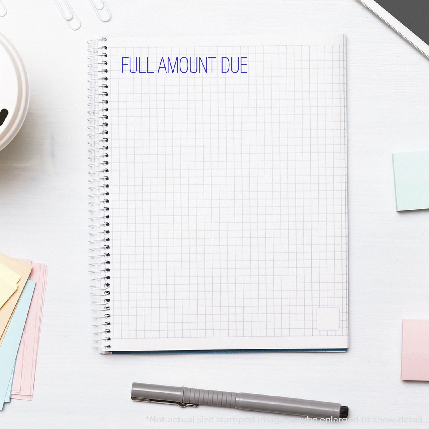 Notebook page on an office desk with FULL AMOUNT DUE text, signaling an invoice payment deadline.